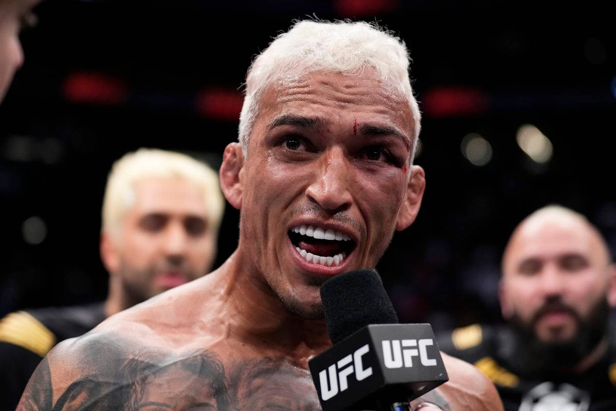 MMA 桌布 壁紙 — 一個滿身大汗、有刺青、白髮的戰士在殘酷比賽後滿臉鮮血對著UFC麥克風尖叫。