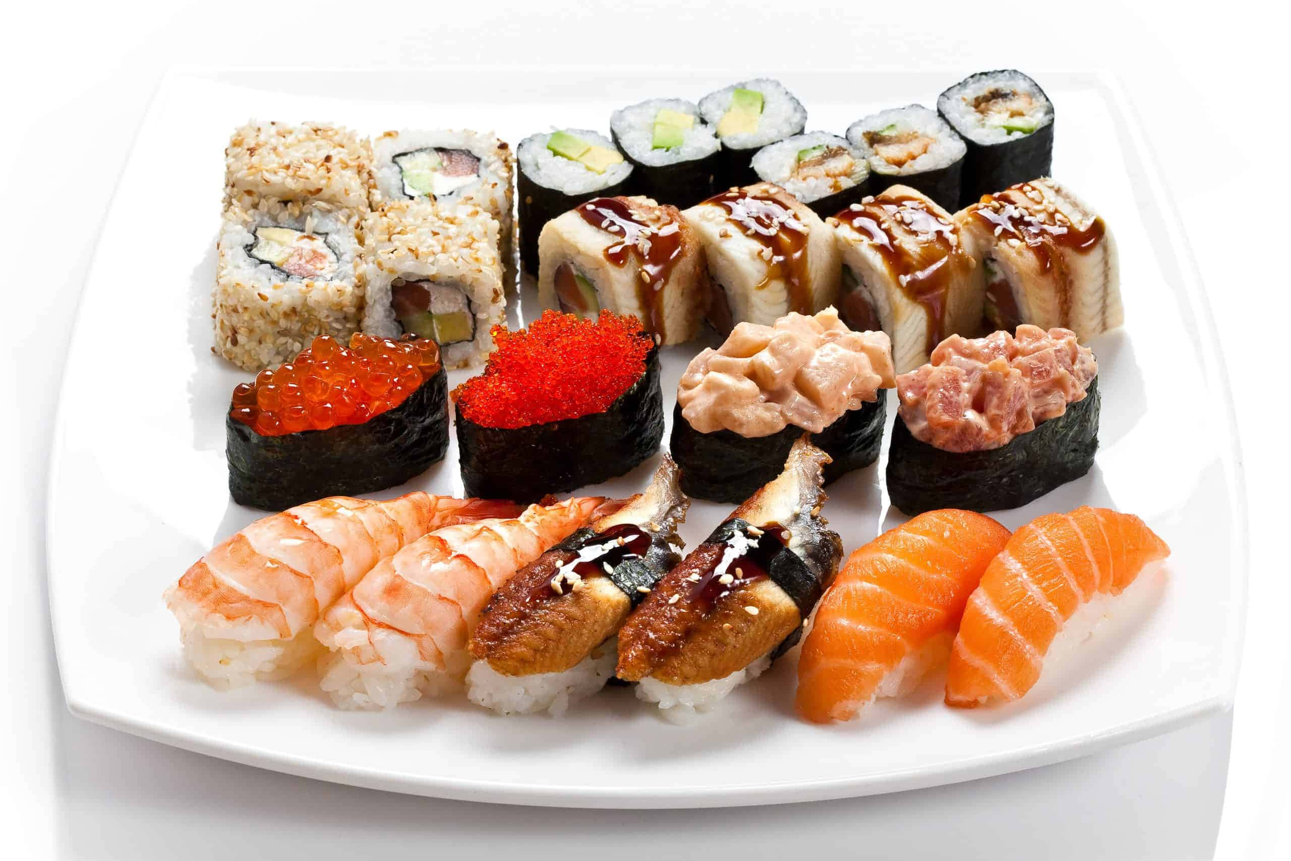 Types Of Sushi 桌布 壁紙 — 一個潔白的盤子上展示著色彩繽紛的壽司藝術拼盤，包括鮭魚握壽司、鮪魚卷和配上辣美乃滋的卷物。