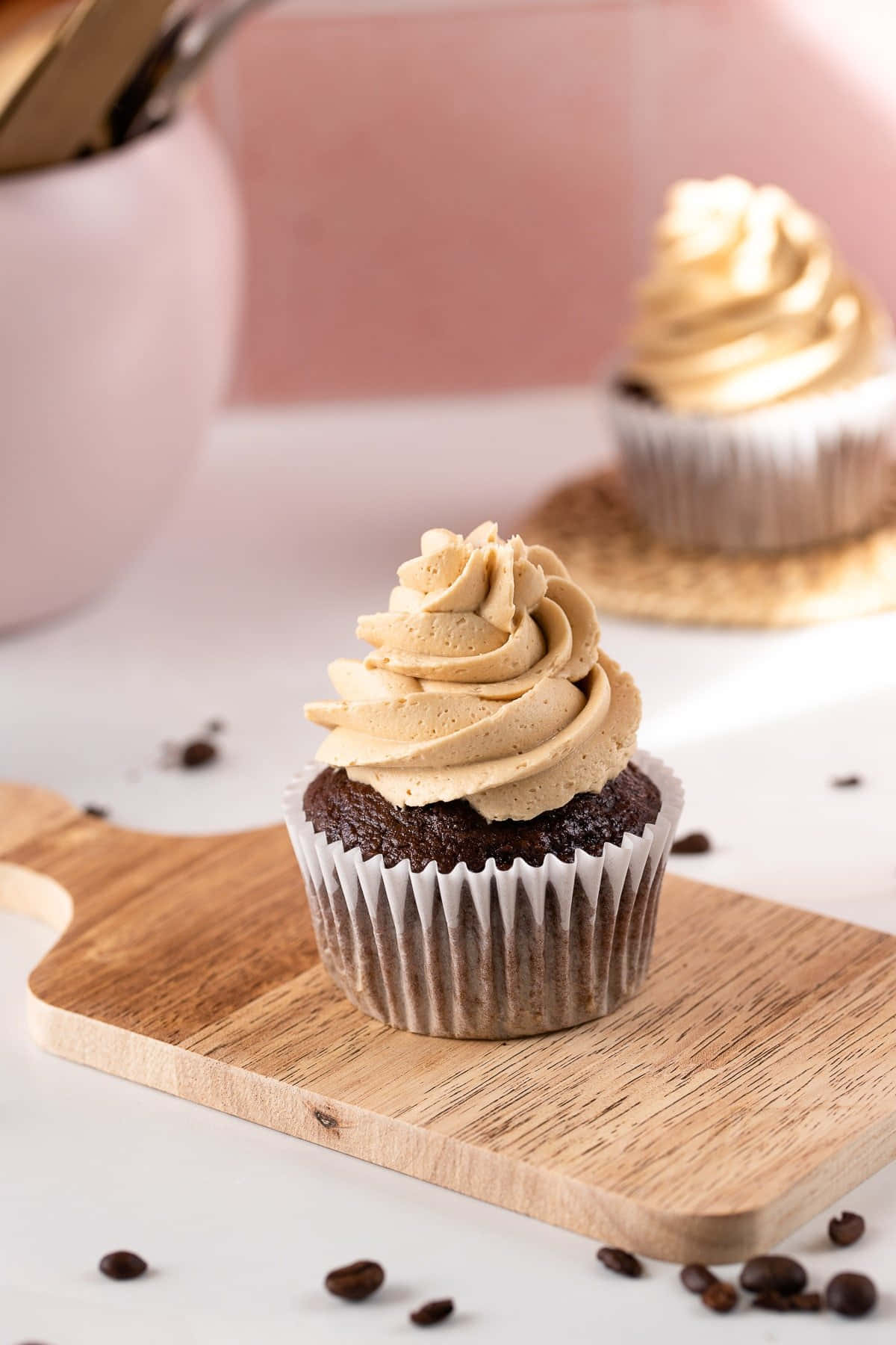Buttercream 桌布 壁紙 — 一個濃郁的巧克力紙杯蛋糕配上 creamy 焦糖糖霜，放在木板上，周圍環繞著咖啡豆。