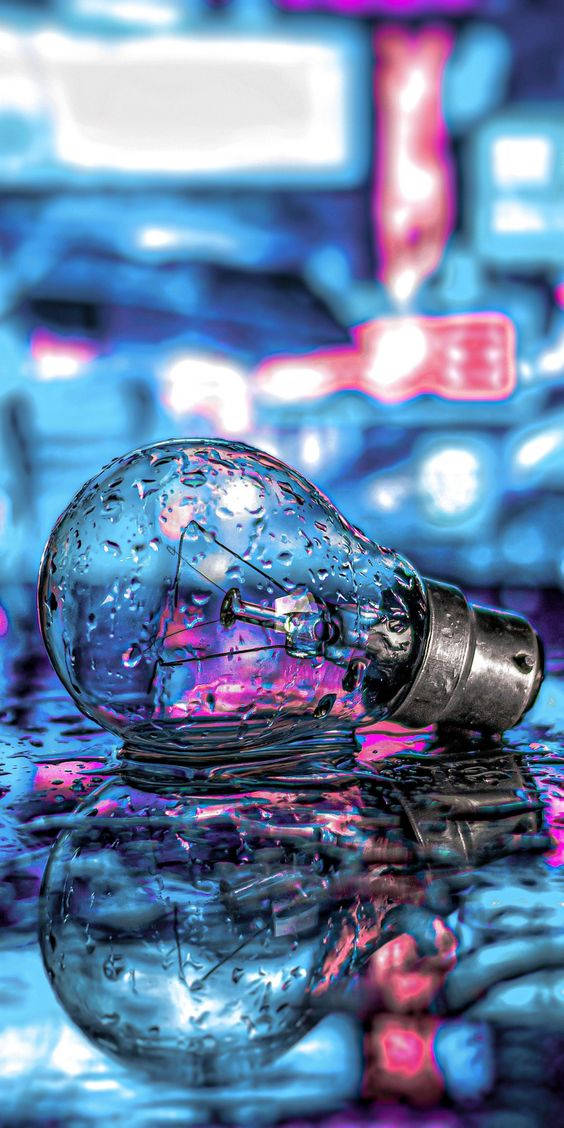 dark neon iPhone 桌布 壁紙 — 一個濕燈泡放在水中，反射出帶有藍色和粉紅色調的霓虹城市燈光。