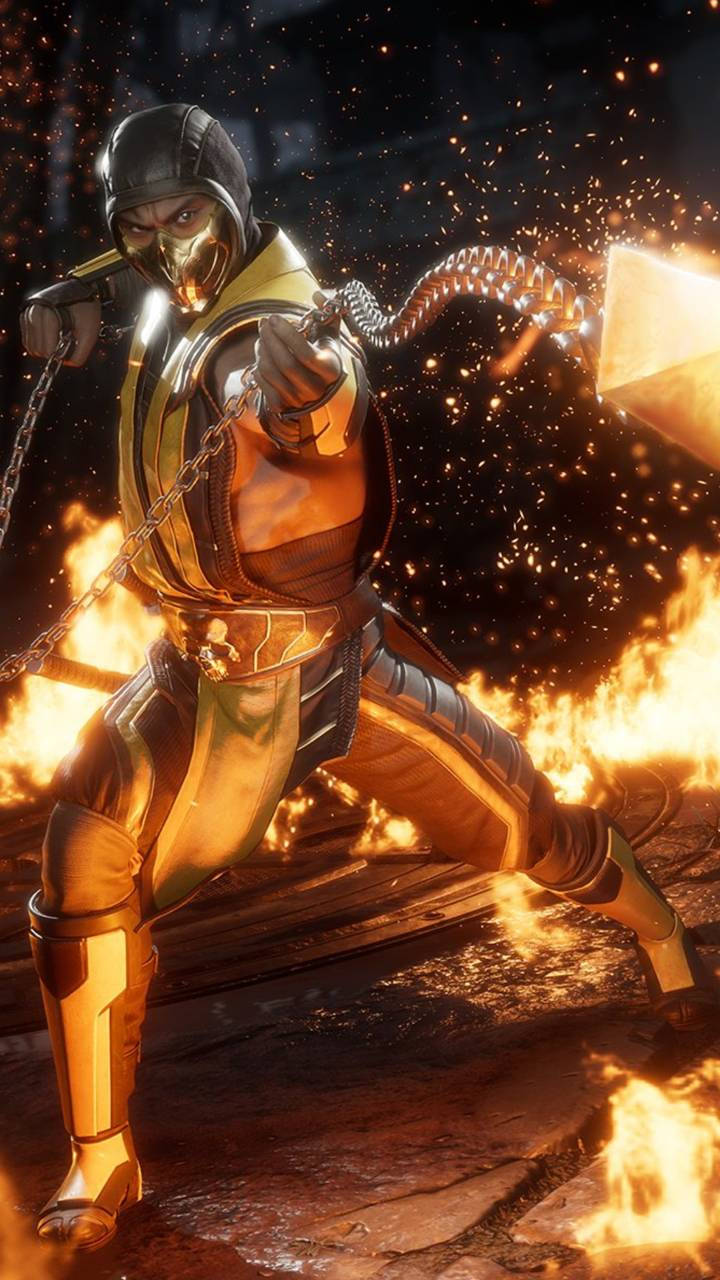 Mk11 桌布 壁紙 — 一個火熱的金色裝甲戰士，擺出動態戰鬥姿勢，周圍環繞著爆炸性的火花和火焰。