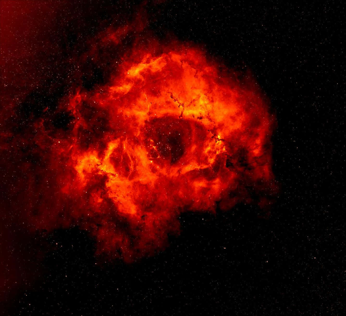 Interstellar Cloud 桌布 壁紙 — 一個火紅色的星雲在佈滿星星的黑色宇宙虛空中戲劇性地旋轉。