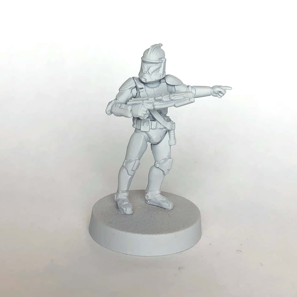 The Clone Army 桌布 壁紙 — 一個灰色未上色的星際大戰複製人士兵迷你模型站在圓形底座上，用爆能槍指向前方。