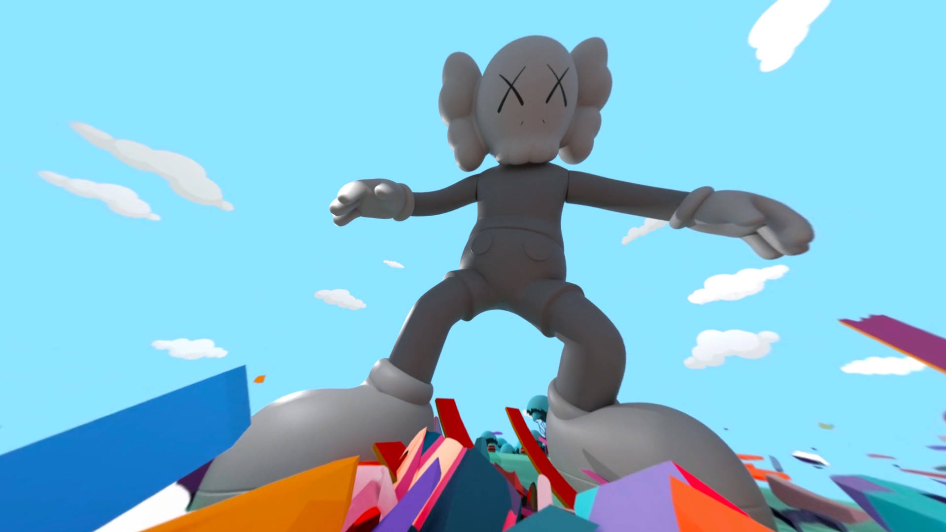 KAWS 桌布 壁紙 — 一個灰色的KAWS人偶勝利地站在一堆色彩繽紛的幾何碎片上，背景是晴朗的藍天和蓬鬆的白雲。