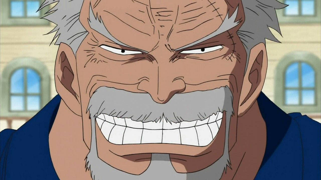 Garp 桌布 壁紙 — 一個灰色頭髮和鬍鬚的動漫角色，在建築物背景下露出牙齒，兇狠地咧嘴笑。