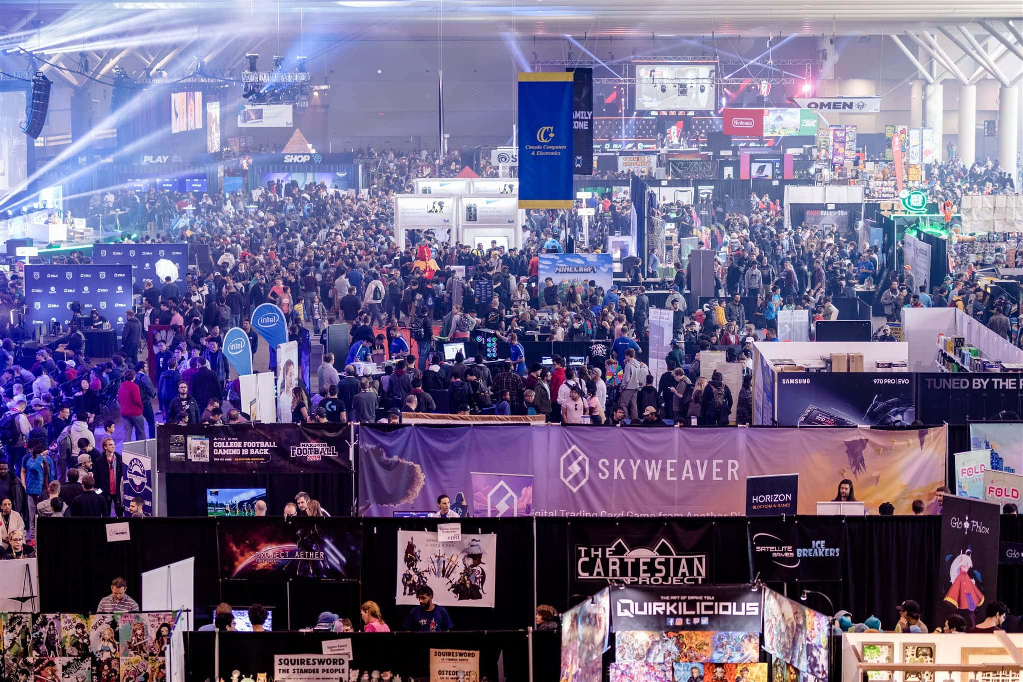 Gaming Conventions 桌布 壁紙 — 一個熙熙攘攘的遊戲展覽廳，人群在明亮的聚光燈和彩色橫幅下探索供應商攤位。