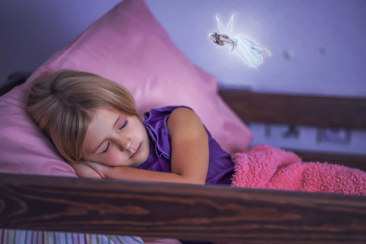 Tooth Fairy 桌布 壁紙 — 一個熟睡的孩子在木床上安詳地休息，一個發光的仙子帶著柔和的光芒在她上方盤旋。
