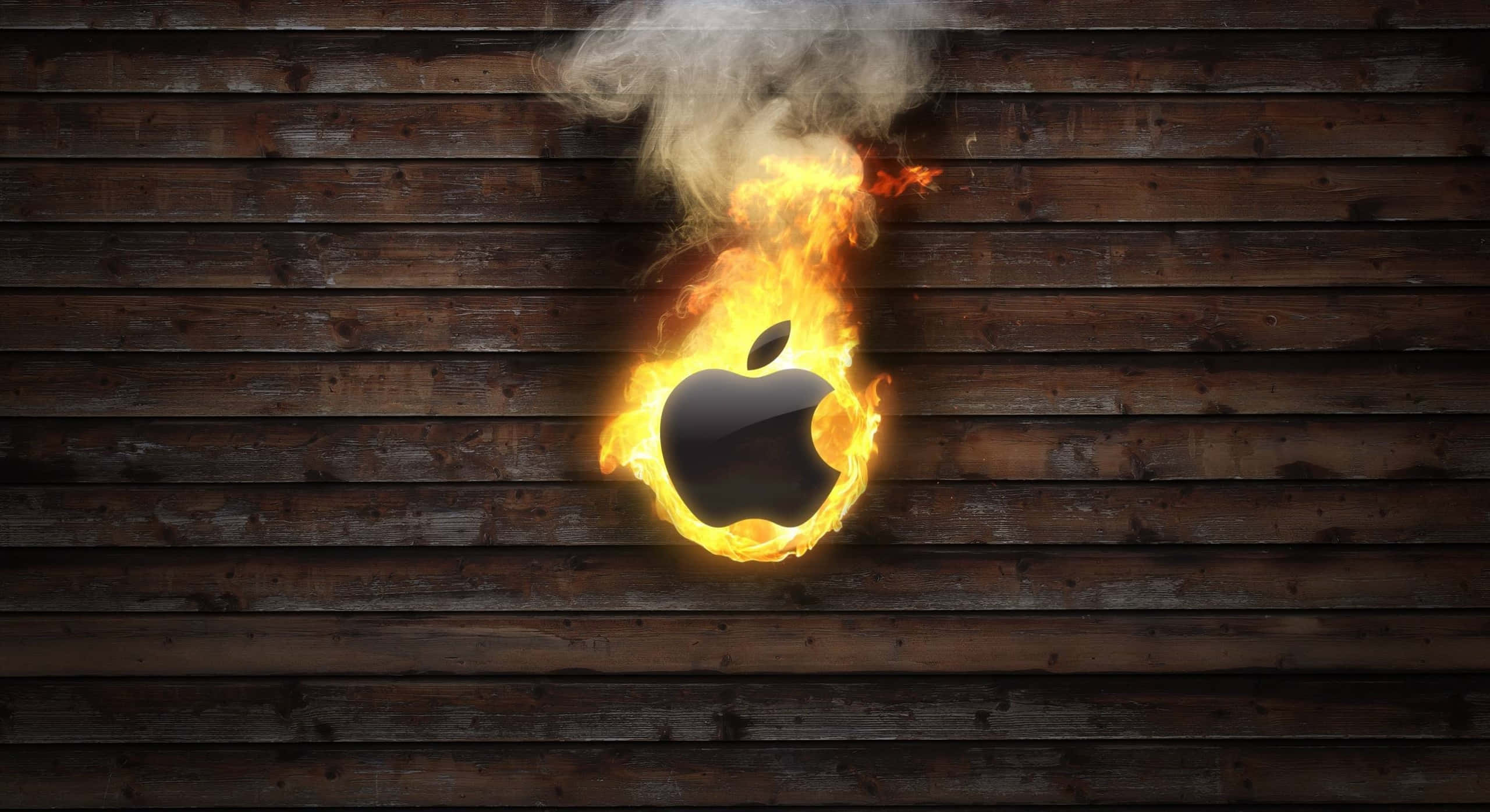 Best Apple 桌布 壁紙 — 一個燃燒的Apple標誌在深色木板上猛烈燃燒，煙霧升騰。