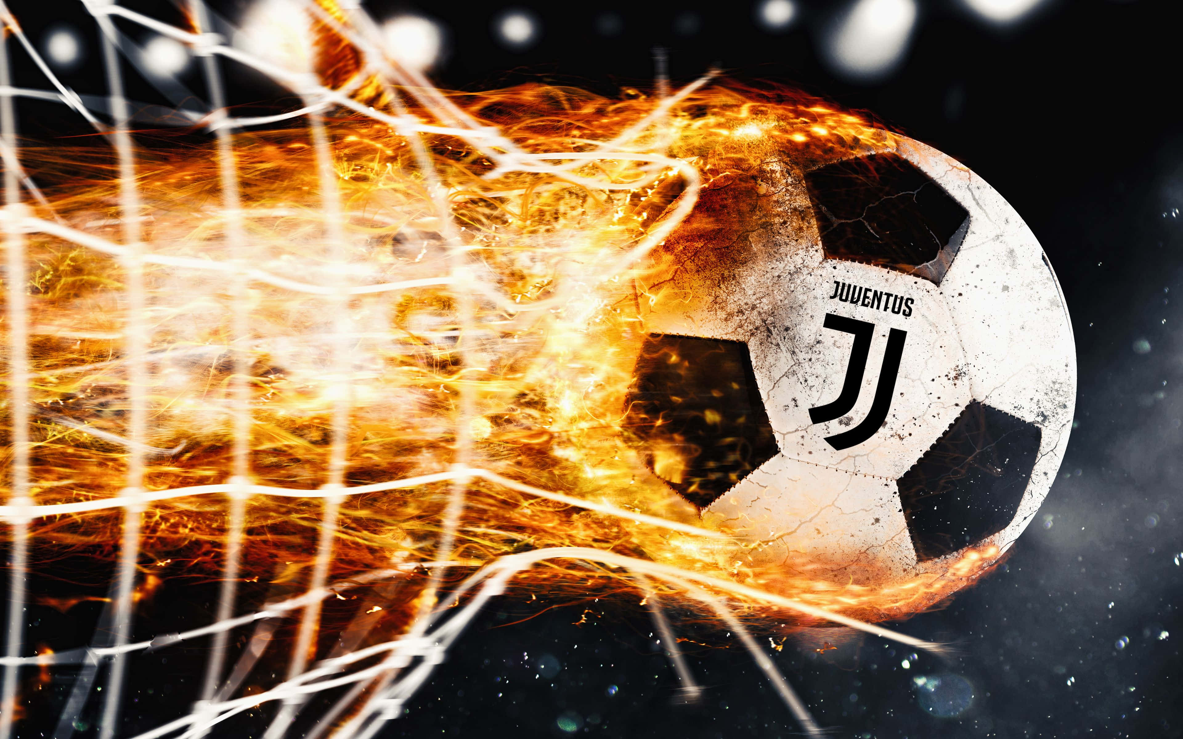 Football On Fire 桌布 壁紙 — 一個燃燒的尤文圖斯足球帶著火痕衝破球網，背景是黑暗的宇宙。