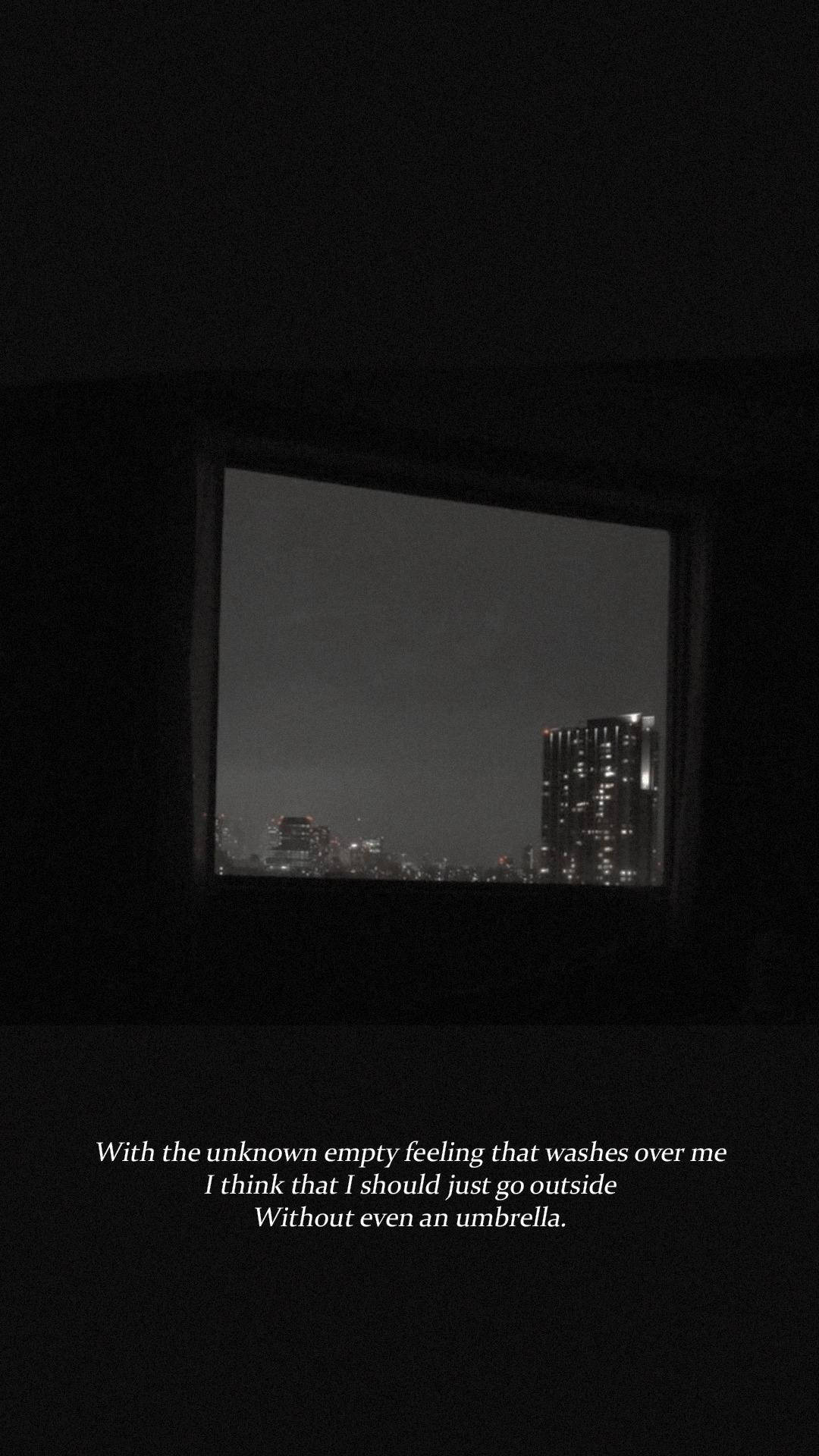 美學 BTS 桌布 壁紙 — 一個燈光昏暗的房間框住了一扇窗，窗外展現出夜晚的城市景觀，摩天大樓在黑暗的天空中閃閃發光。