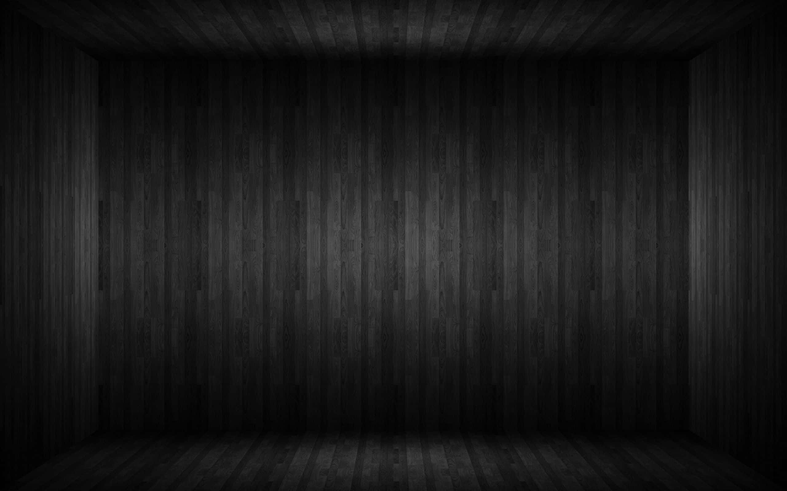 Black Wood 桌布 壁紙 — 一個燈光昏暗的空房間，牆壁、天花板和地板都鋪設深色木鑲板，營造出陰鬱的極簡主義氛圍。
