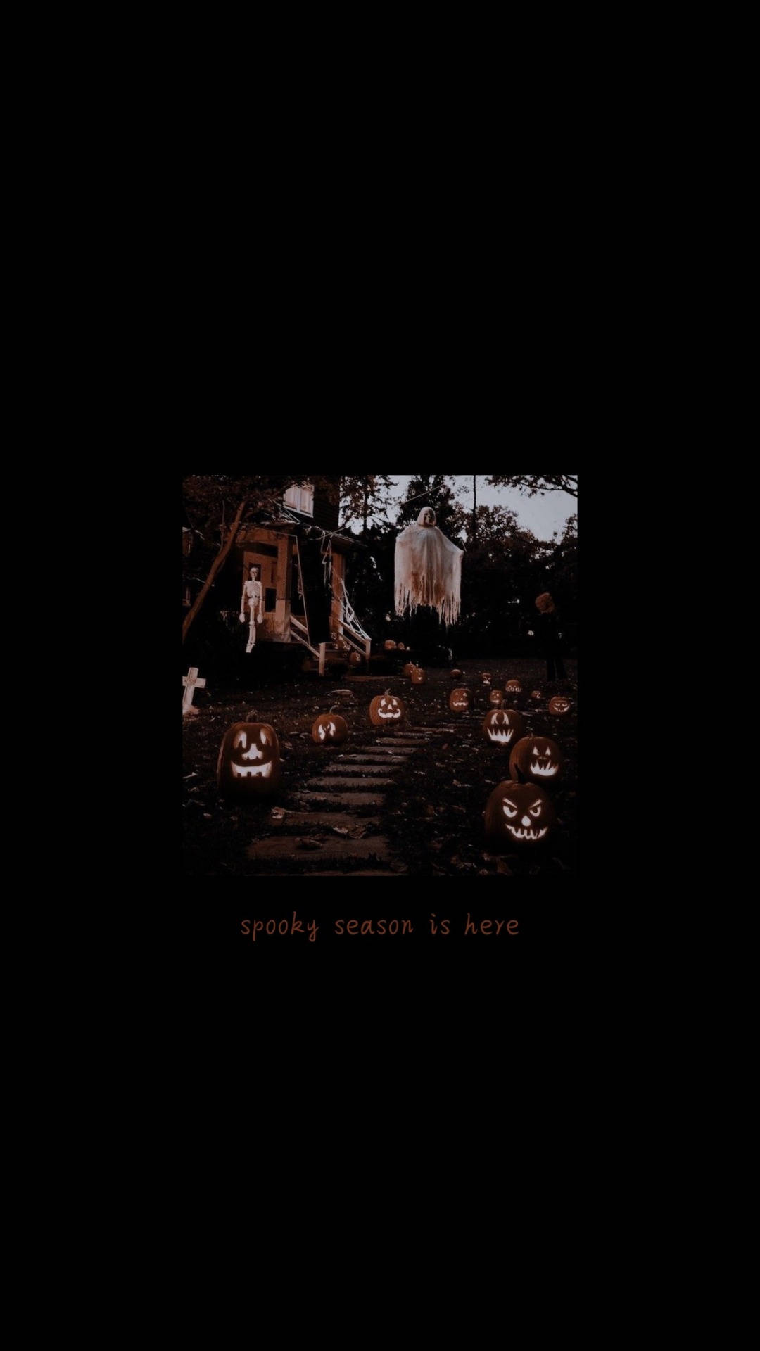 Spooky Aesthetic 桌布 壁紙 — 一個燈光昏暗的萬聖節庭院，充滿了發光的傑克南瓜燈和掛在樹上的鬼影。