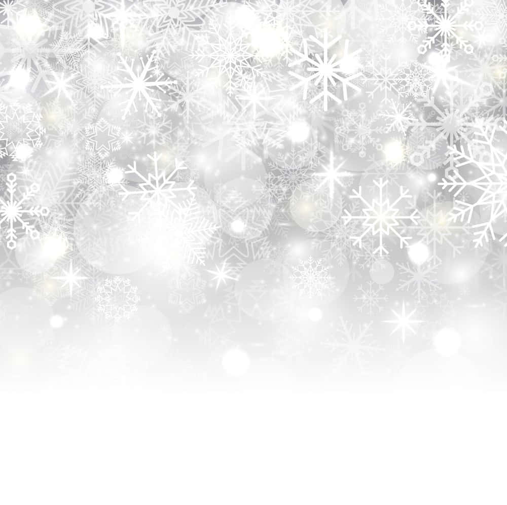 White Snow 桌布 壁紙 — 一個燦爛的冬日場景，精緻的白色雪花和發光的散景光線映襯在柔和的銀色漸變背景上。