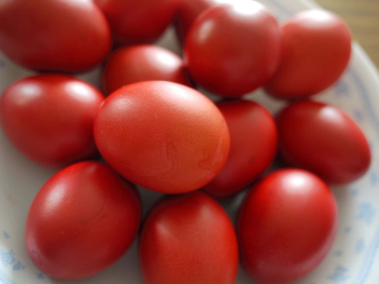 Eggs 桌布 壁紙 — 一個特寫，展示白色帶藍色花卉圖案的碗中，光滑的紅色雞蛋。