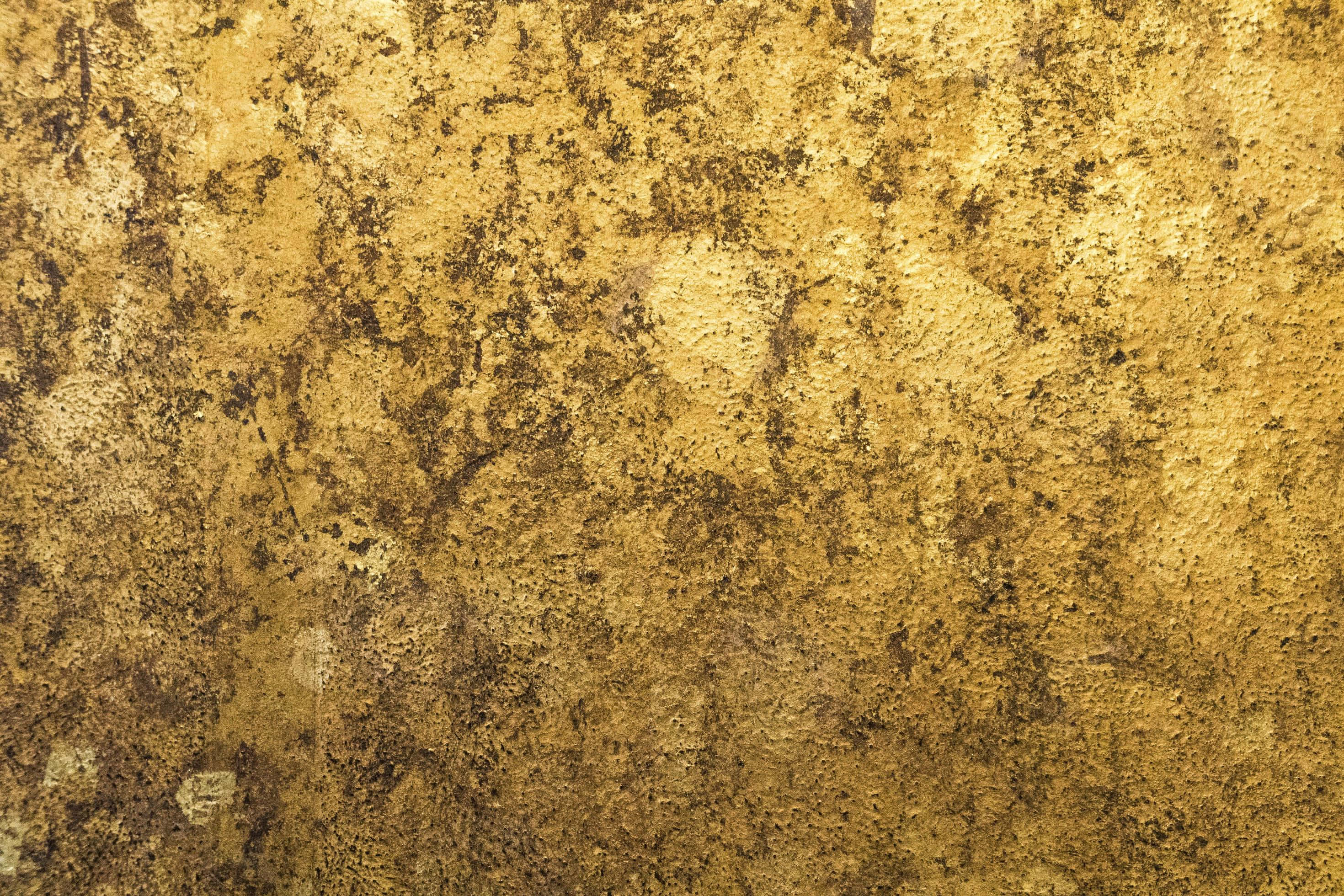 Gold Texture 桌布 壁紙 — 一個特寫，展示經風化的金色表面，帶有深色斑點和紋理裂縫，顯露出老化的銅綠。