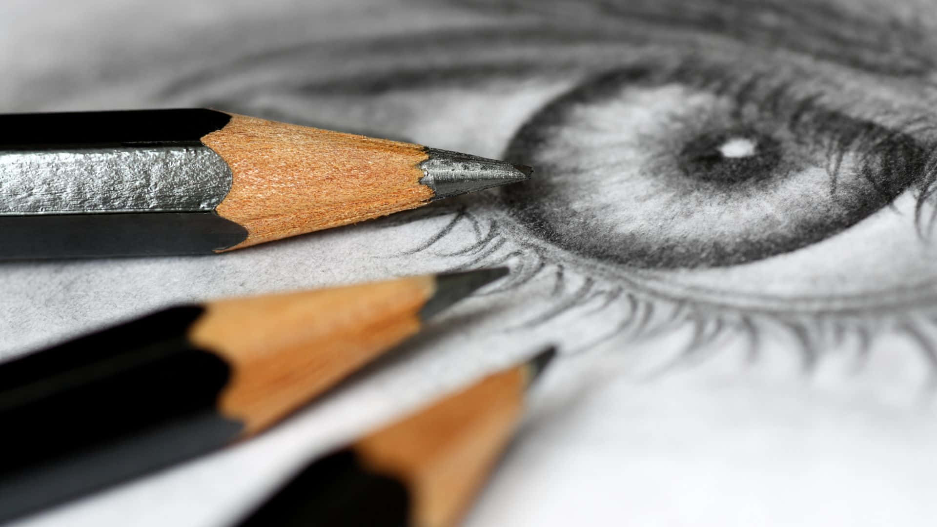 Eye 桌布 壁紙 — 一個特寫，描繪了一個詳細的鉛筆素描眼睛，削尖的鉛筆放在紙上。