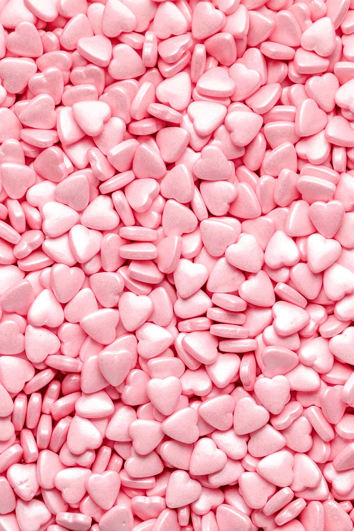 Pink Candy 桌布 壁紙 — 一個特寫，顯示光澤粉紅色心形糖果灑密集覆蓋框架。