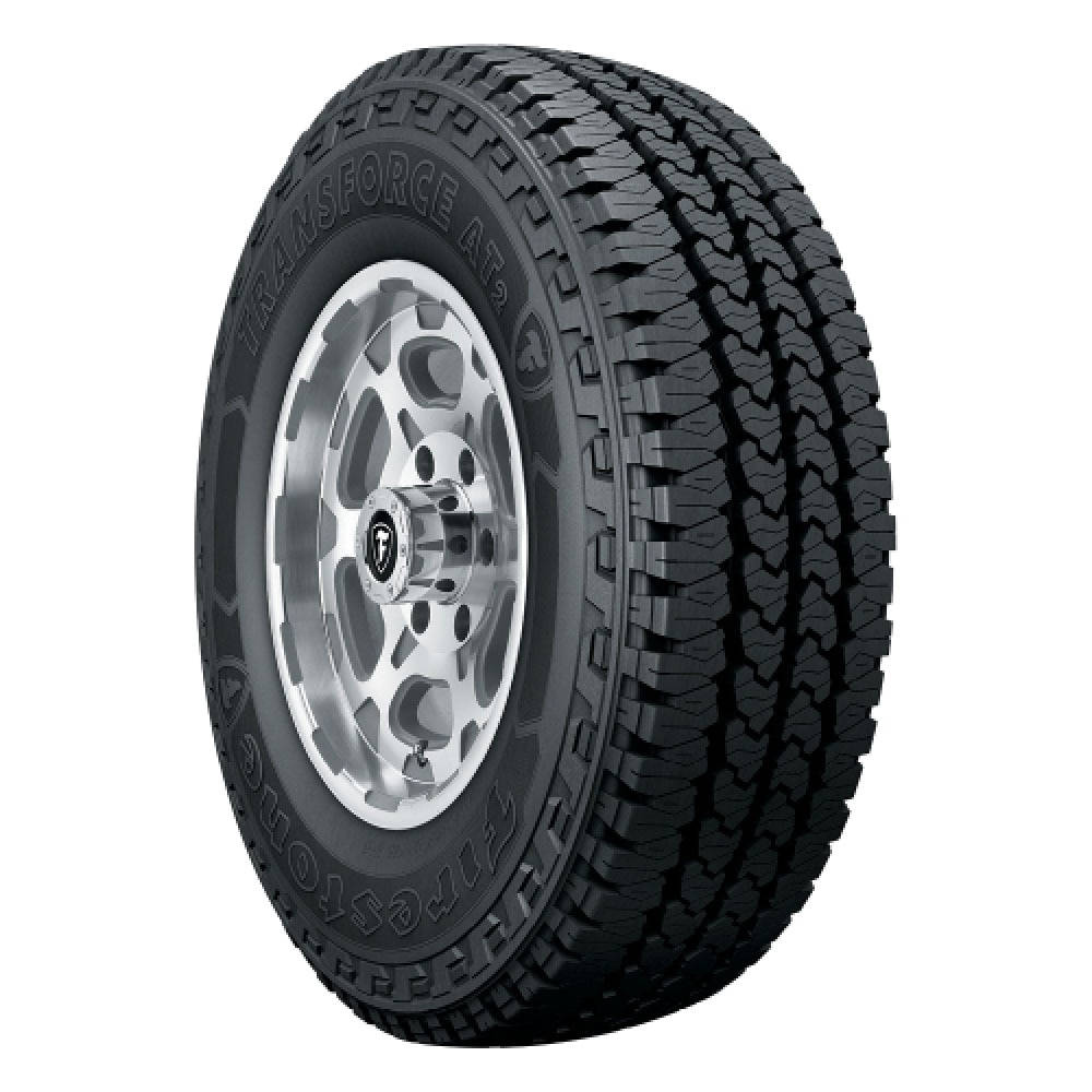 Firestone 桌布 壁紙 — 一個特寫工作室拍攝，黑色Firestone Transforce AT2全地形輪胎安裝在銀色多輻輪圈上，背景為白色。