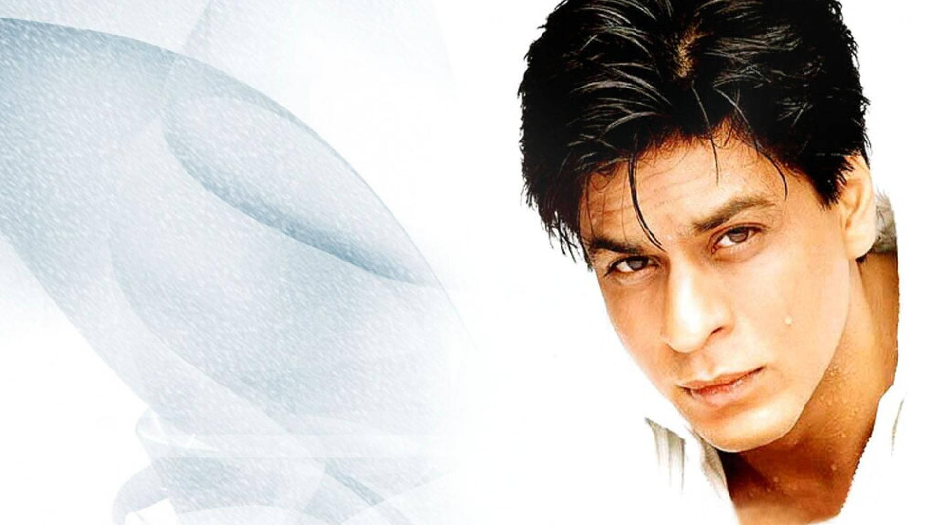 Shah Rukh Khan 桌布 壁紙 — 一個特寫肖像，一個深色頭髮、眼神強烈的男人，背景是柔和的藍白漩渦抽象背景。