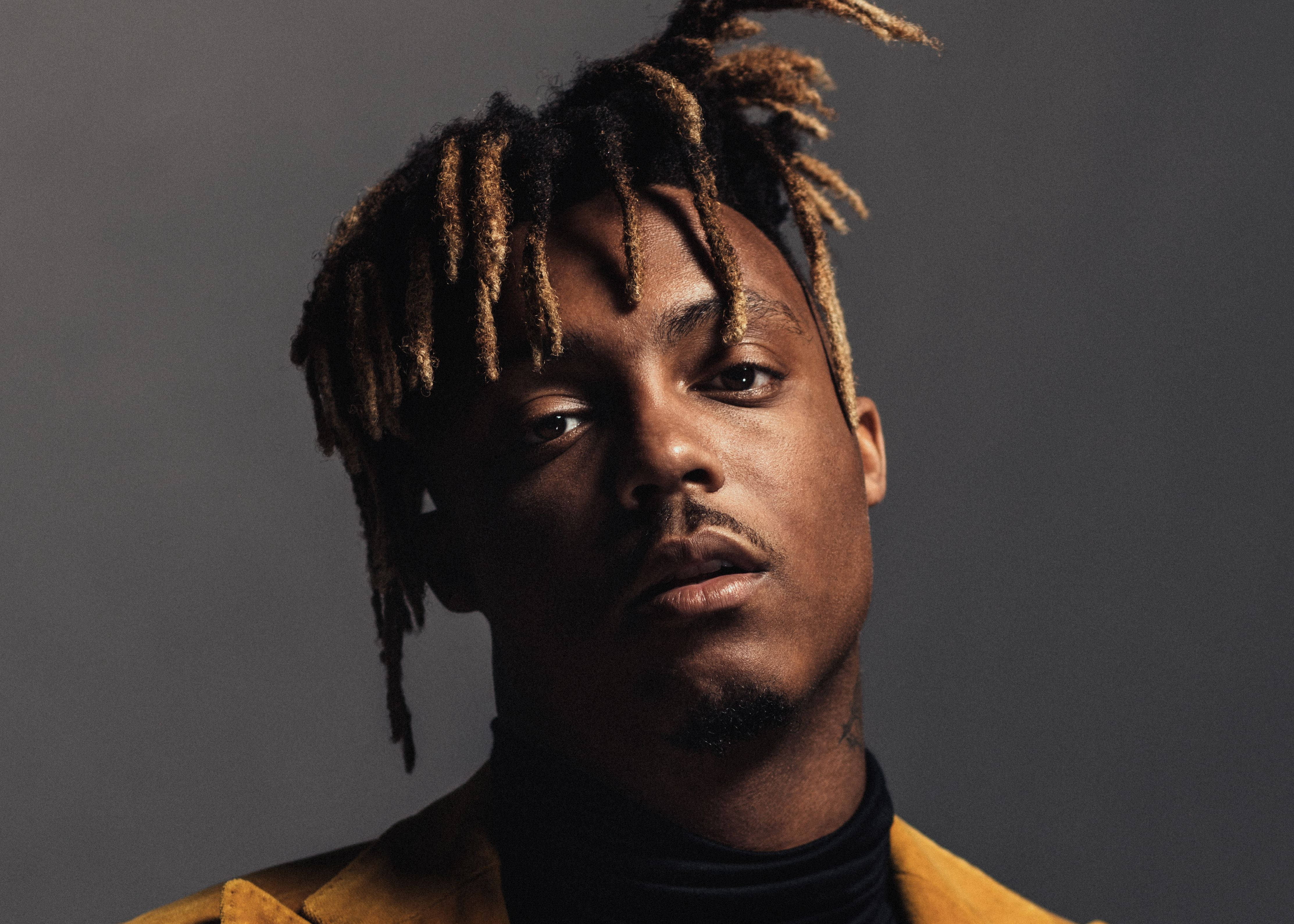 Juice Wrld Desktop 桌布 壁紙 — 一個特寫肖像，一個辮子頭髮的男人穿著黃色外套，背景是灰色。