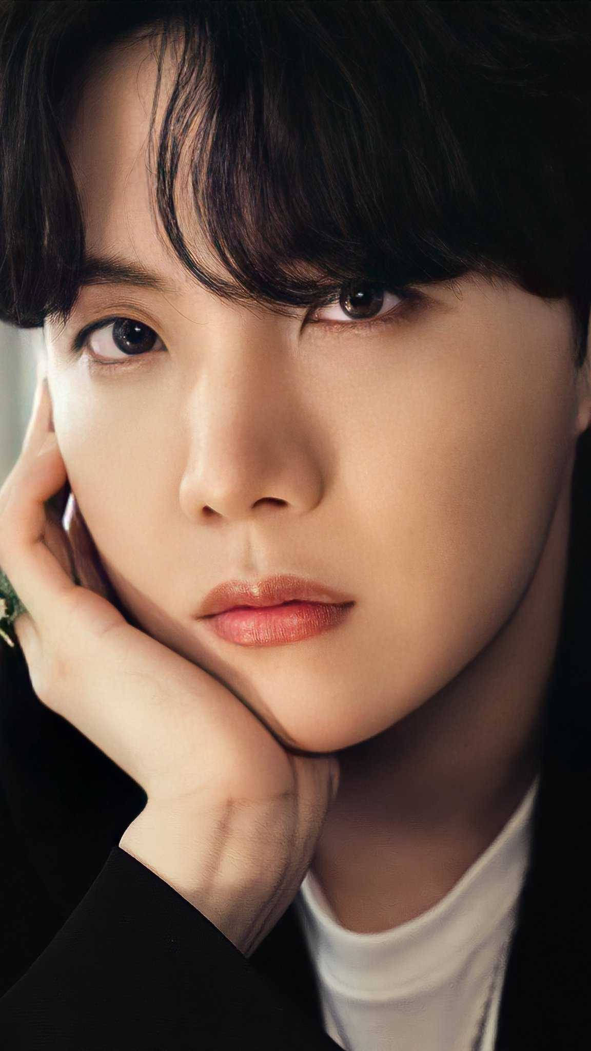jhope 桌布 壁紙 — 一個特寫肖像，一個黑髮年輕男子將下巴擱在手上，背景為深色。