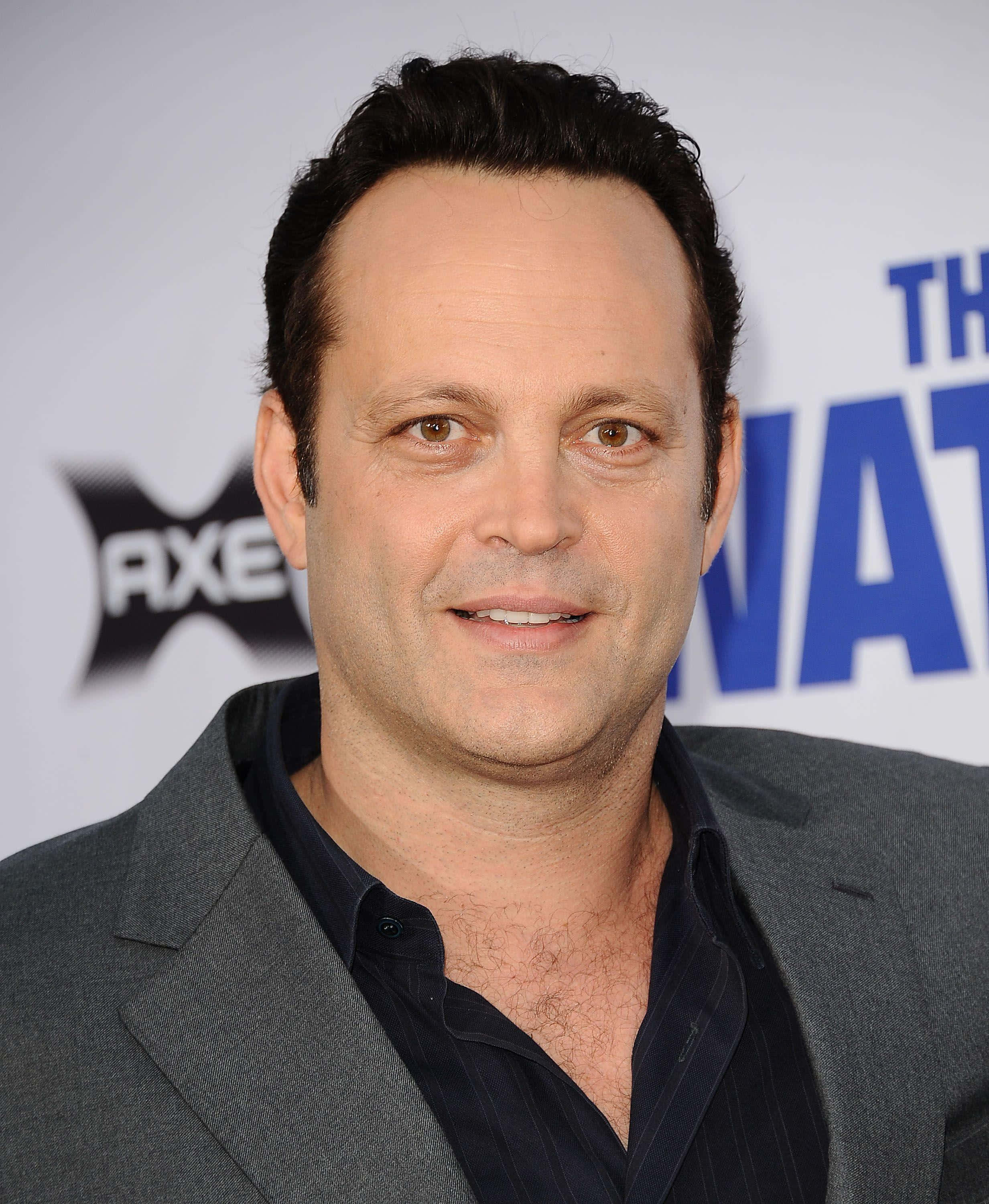 Vince Vaughn 桌布 壁紙 — 一個特寫肖像，一名深色頭髮和棕色眼睛的男子在推廣活動中穿著灰色西裝外套，內搭深色襯衫。