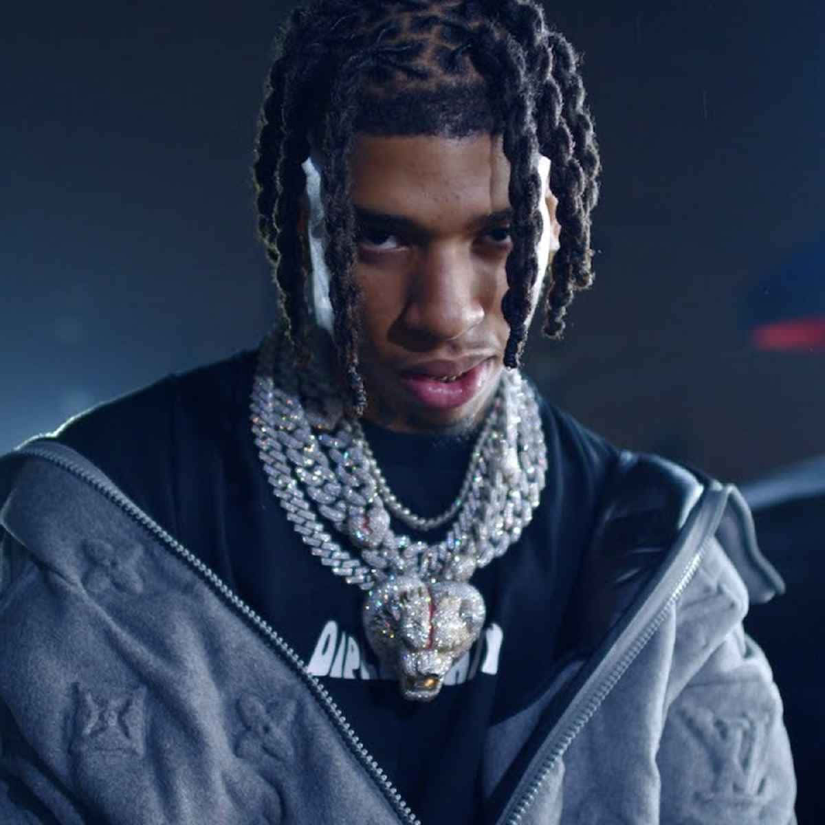 辮子髮型的男子佩戴鑽石項鍊和灰色連帽衫。 — NLE Choppa GIF 壁紙