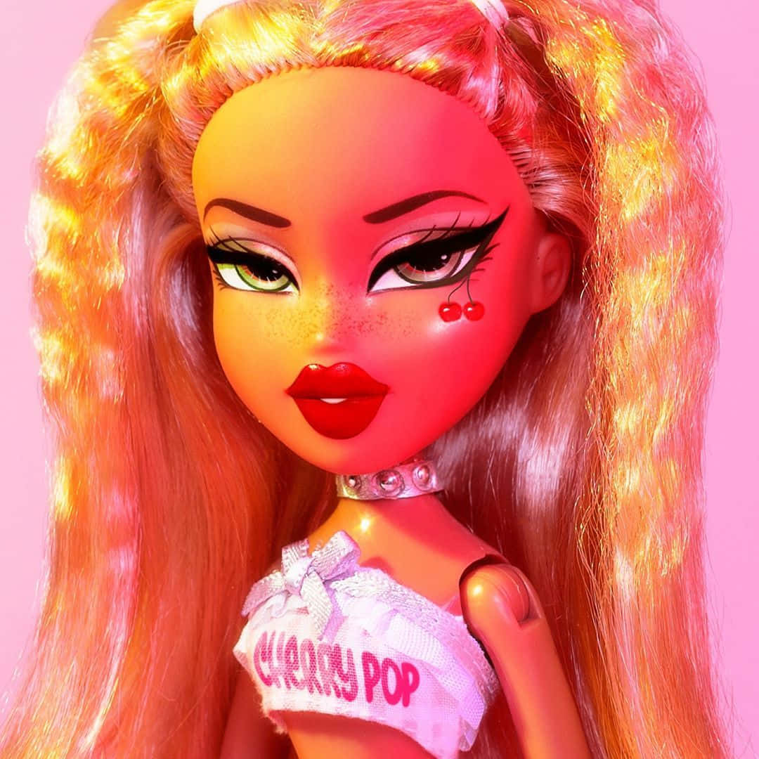 Bratz 桌布 壁紙 — 一個特寫鏡頭，一個擁有火橙色頭髮和櫻桃臉頰裝飾的娃娃，背景為粉紅色。