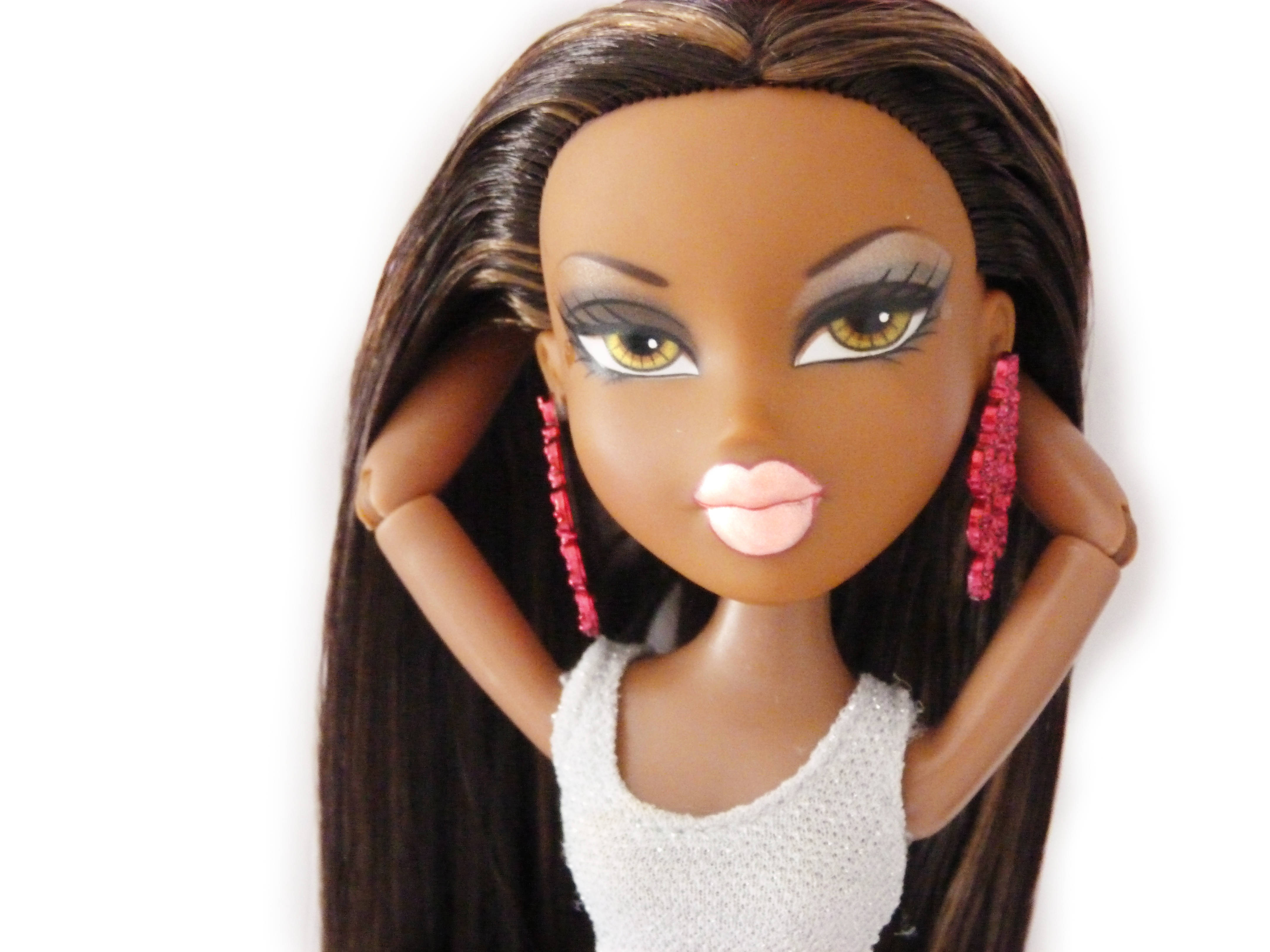 bratz 美學 桌布 壁紙 — 一個特寫鏡頭，一個長長棕色頭髮的娃娃戴著粉紅色珠子耳環和白色上衣，背景是純白色。