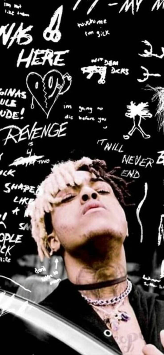 XXXTENTACION 桌布 壁紙 — 一個特寫鏡頭，一名頭髮漂白、頸部有刺青的男子，在一個佈滿混亂白色塗鴉文字和圖畫的黑色背景上向上望。