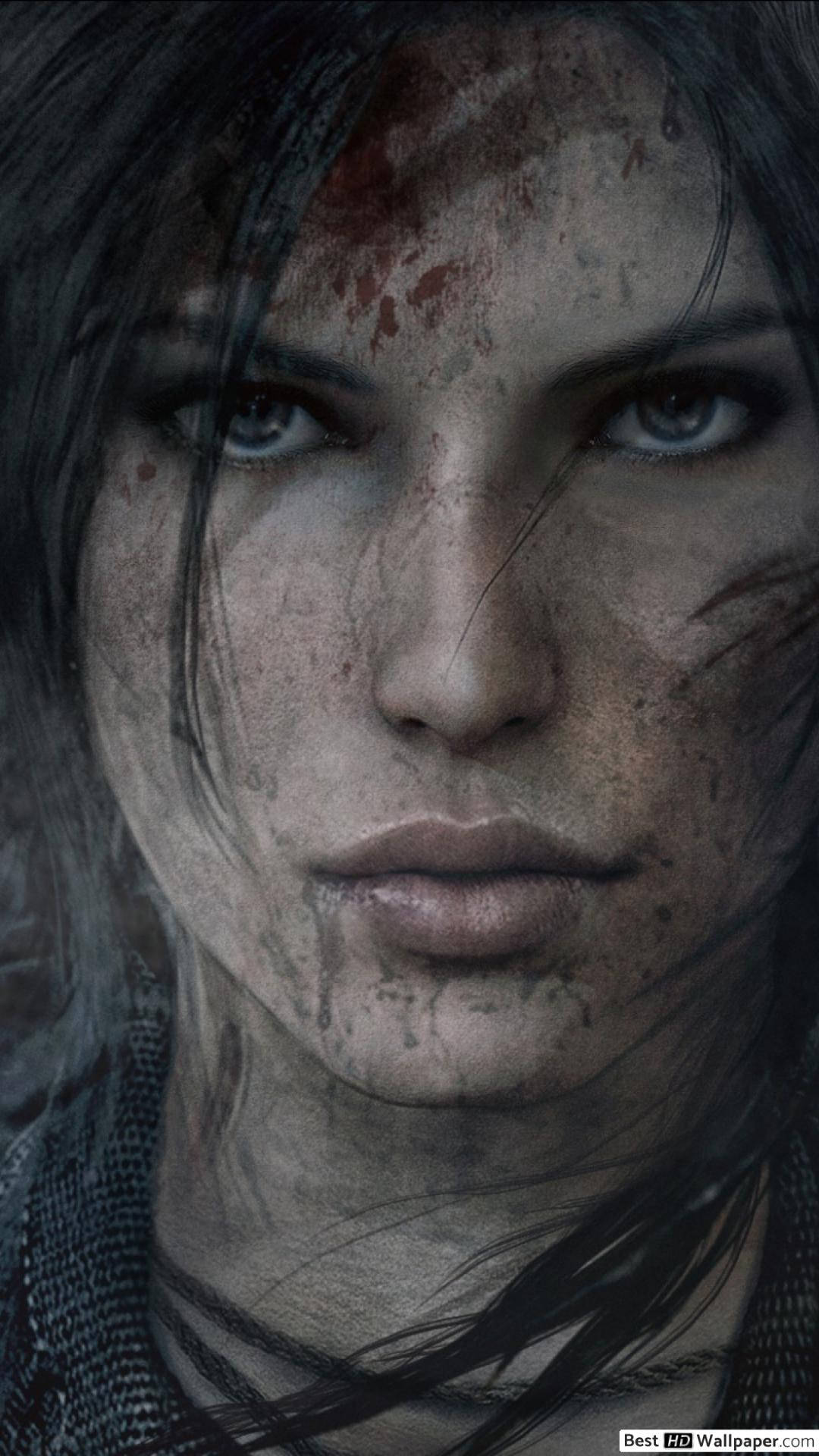 tomb raider iPhone 桌布 壁紙 — 一個特寫鏡頭，展現一位堅定的女性，臉上帶血，藍色眼睛充滿強烈情感，直視觀眾。