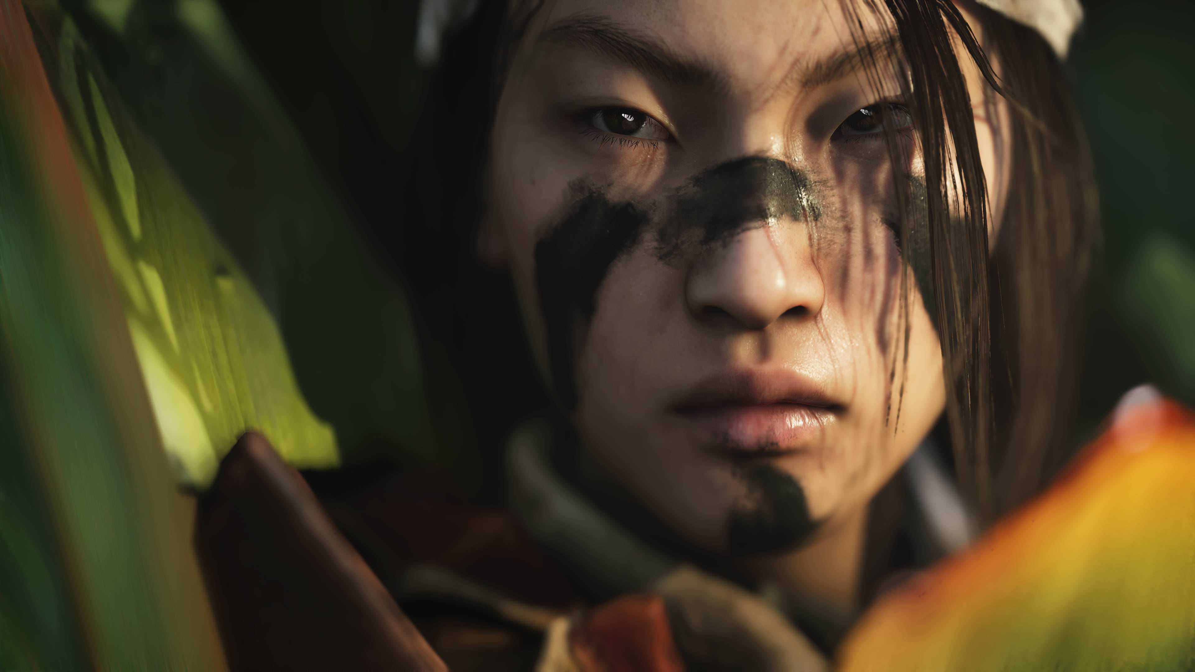 Battlefield 5 桌布 壁紙 — 一個特寫鏡頭，展示一位臉上塗有深色顏料、意志堅定的年輕戰士，從茂密的綠色樹葉中探出頭來。