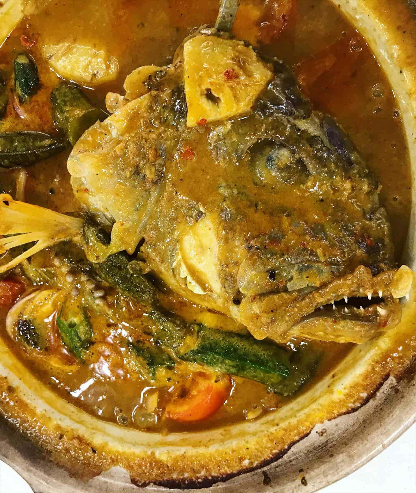 Food Photography 桌布 壁紙 — 一個特寫鏡頭，展示一個陶鍋中蒸騰的魚頭咖哩，配有秋葵和香料。