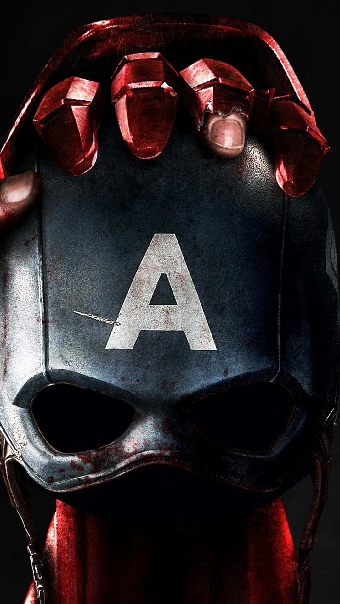 Best Captain America 桌布 壁紙 — 一個特寫鏡頭，展示一個飽經風霜的美國隊長頭盔，一隻戴著紅色手套的手抓住其頂部，背景為深色。