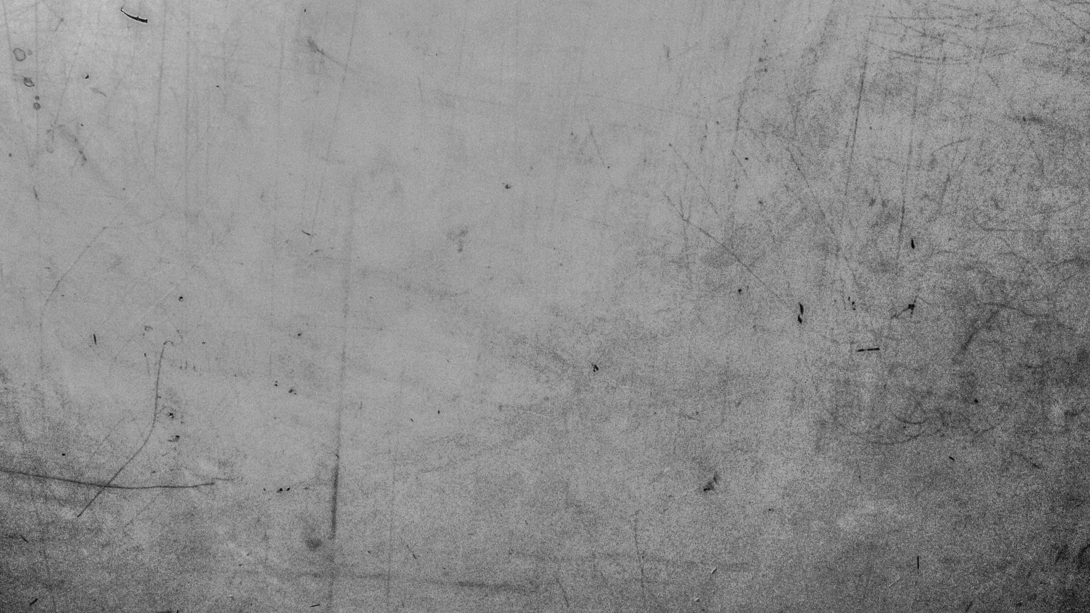灰色美學動圖 桌布 壁紙 — 一個特寫鏡頭，展示一塊佈滿刮痕和磨損的風化金屬表面，帶有粗糙的單色紋理。