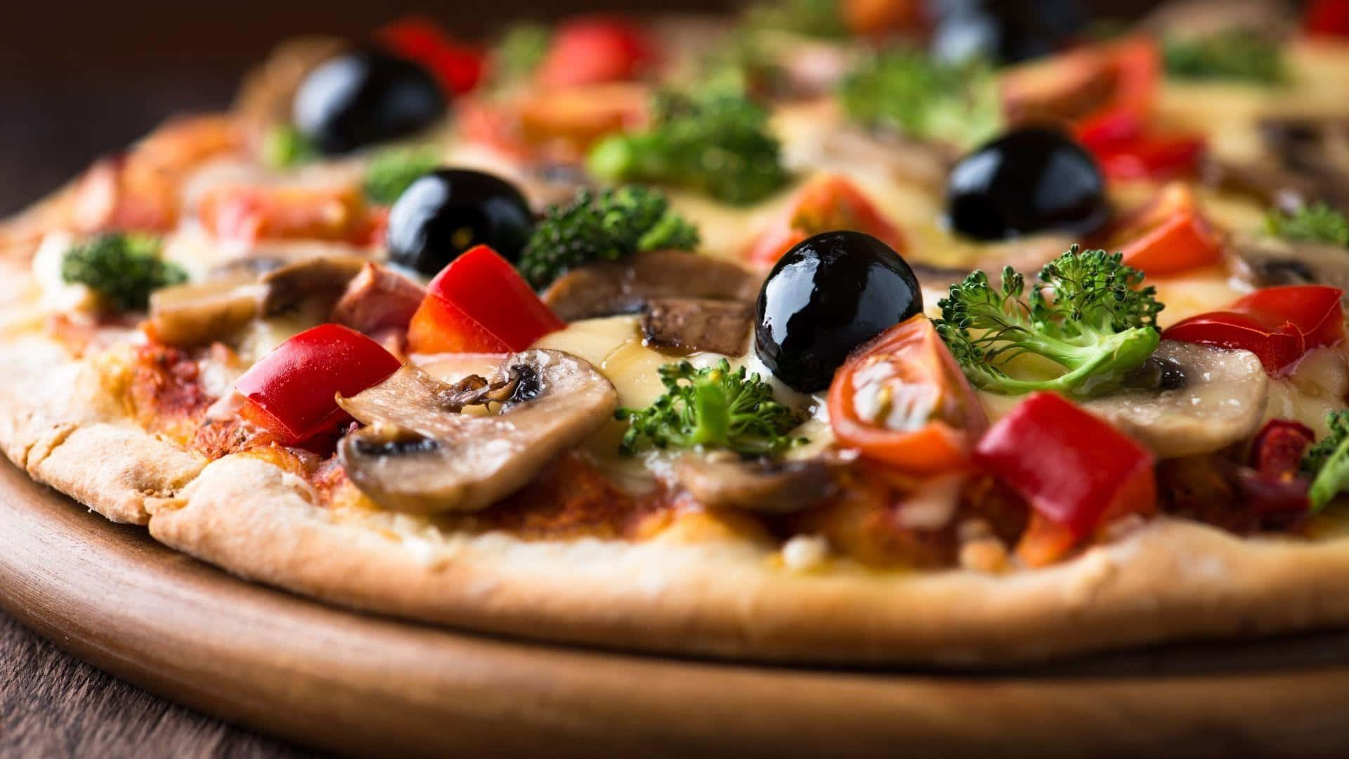 Pizza 桌布 壁紙 — 一個特寫鏡頭，展示一塊木板上放著的美味披薩，上面鋪滿了蘑菇、番茄、橄欖和花椰菜。
