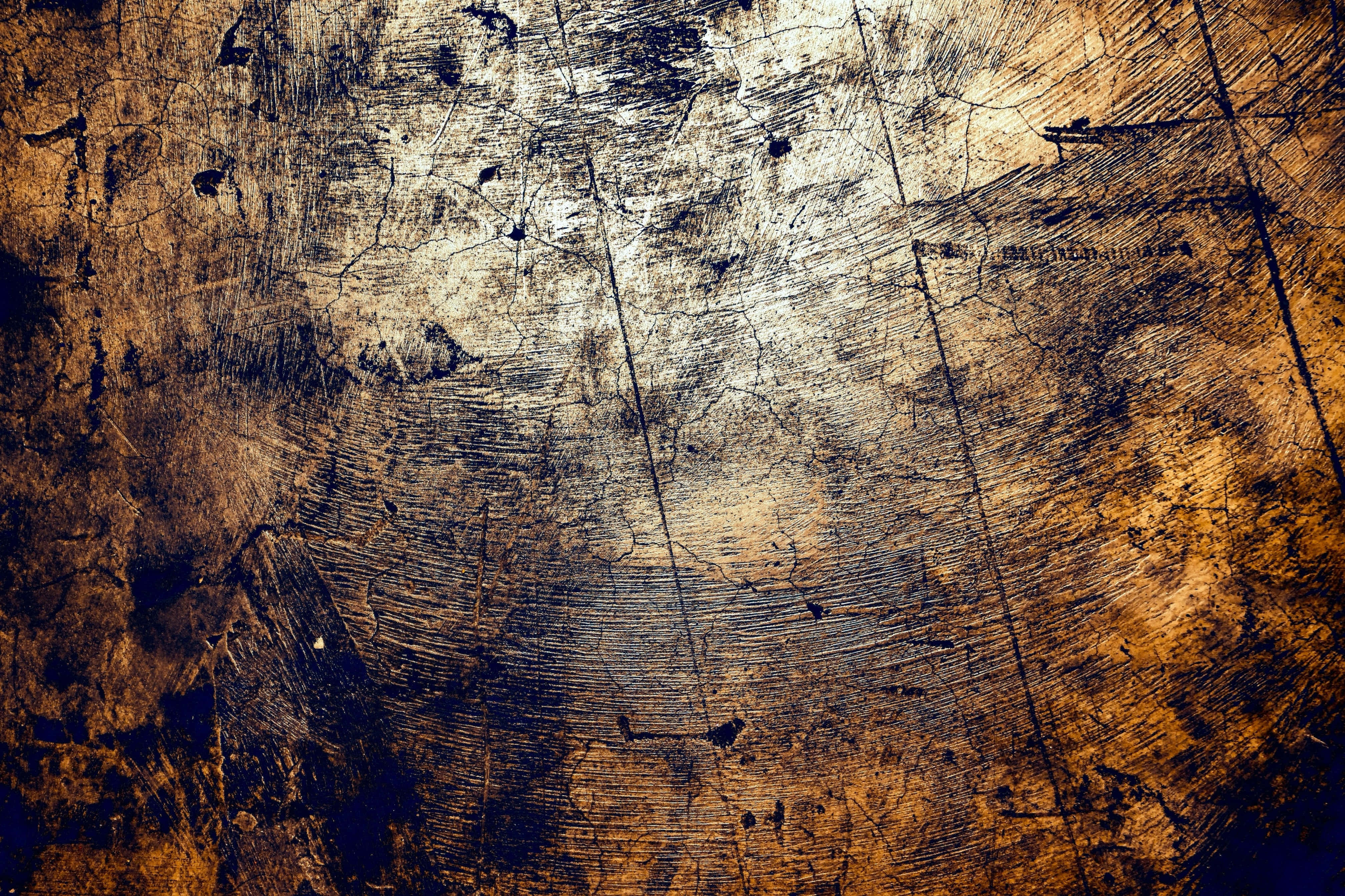 texture 桌布 壁紙 — 一個特寫鏡頭，展示經風化的木質表面，帶有深裂紋和黑色刮痕，顯露層次紋理和溫暖琥珀色調。