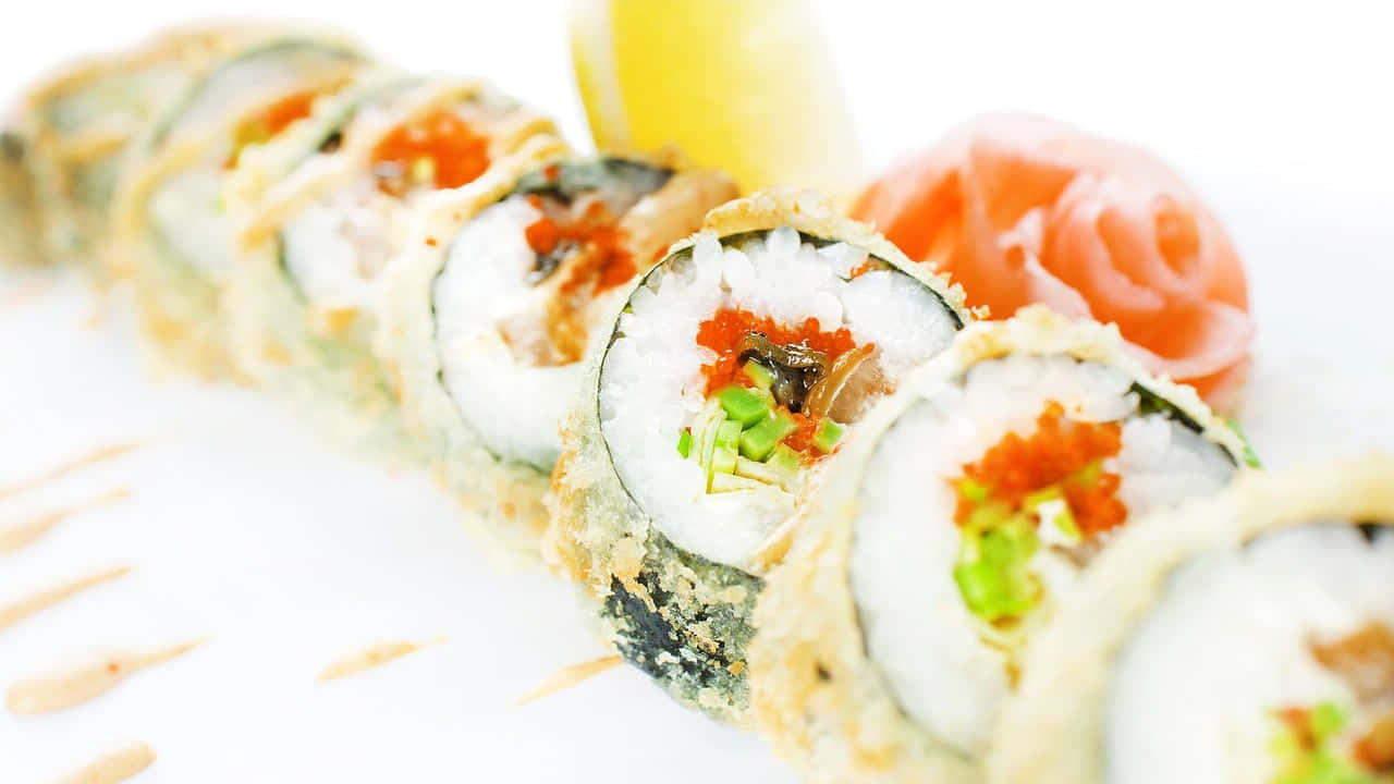 HD Food 桌布 壁紙 — 一個特寫鏡頭，脆皮天婦羅壽司卷上面鋪滿飛魚卵和青蔥，放在白色盤子上，搭配芥末和薑。