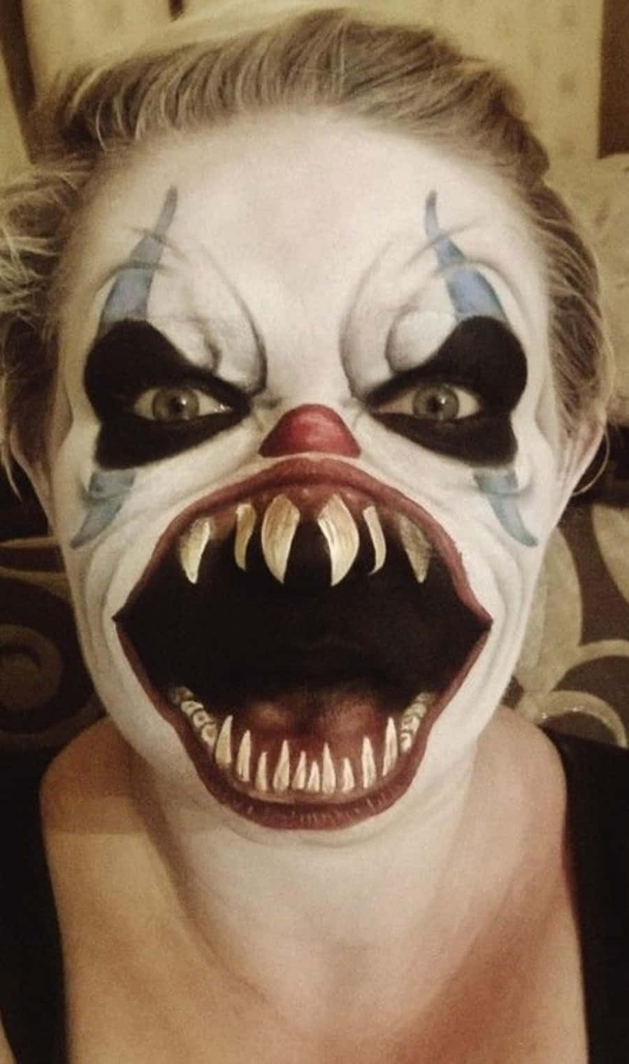 Scary Face 桌布 壁紙 — 一個特寫鏡頭中，化著恐怖小丑妝容的人，擁有寬大的眼睛、尖銳的獠牙和張開的嘴巴。