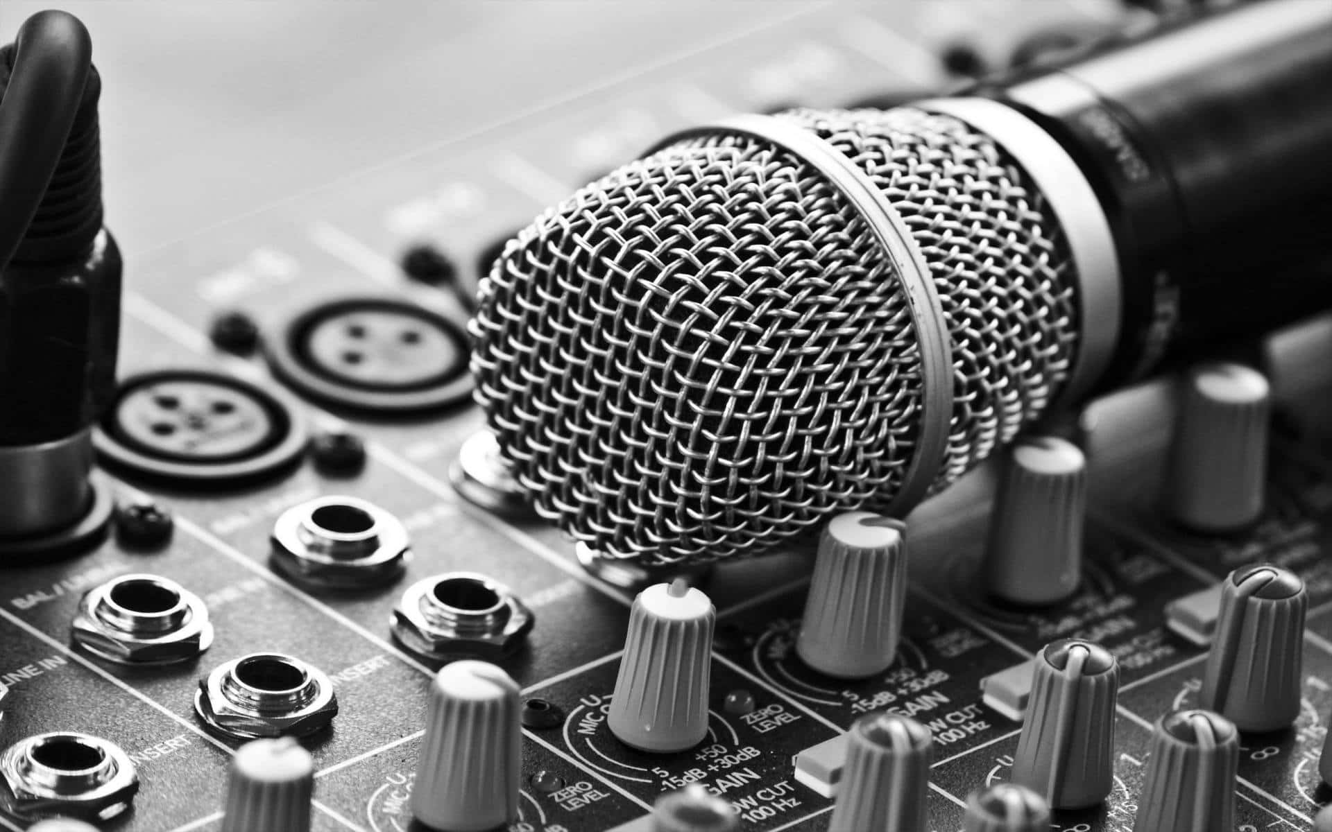 Sound 桌布 壁紙 — 一個特寫黑白鏡頭，顯示一個麥克風放在一個帶有旋鈕和輸入端子的混音控制台上。