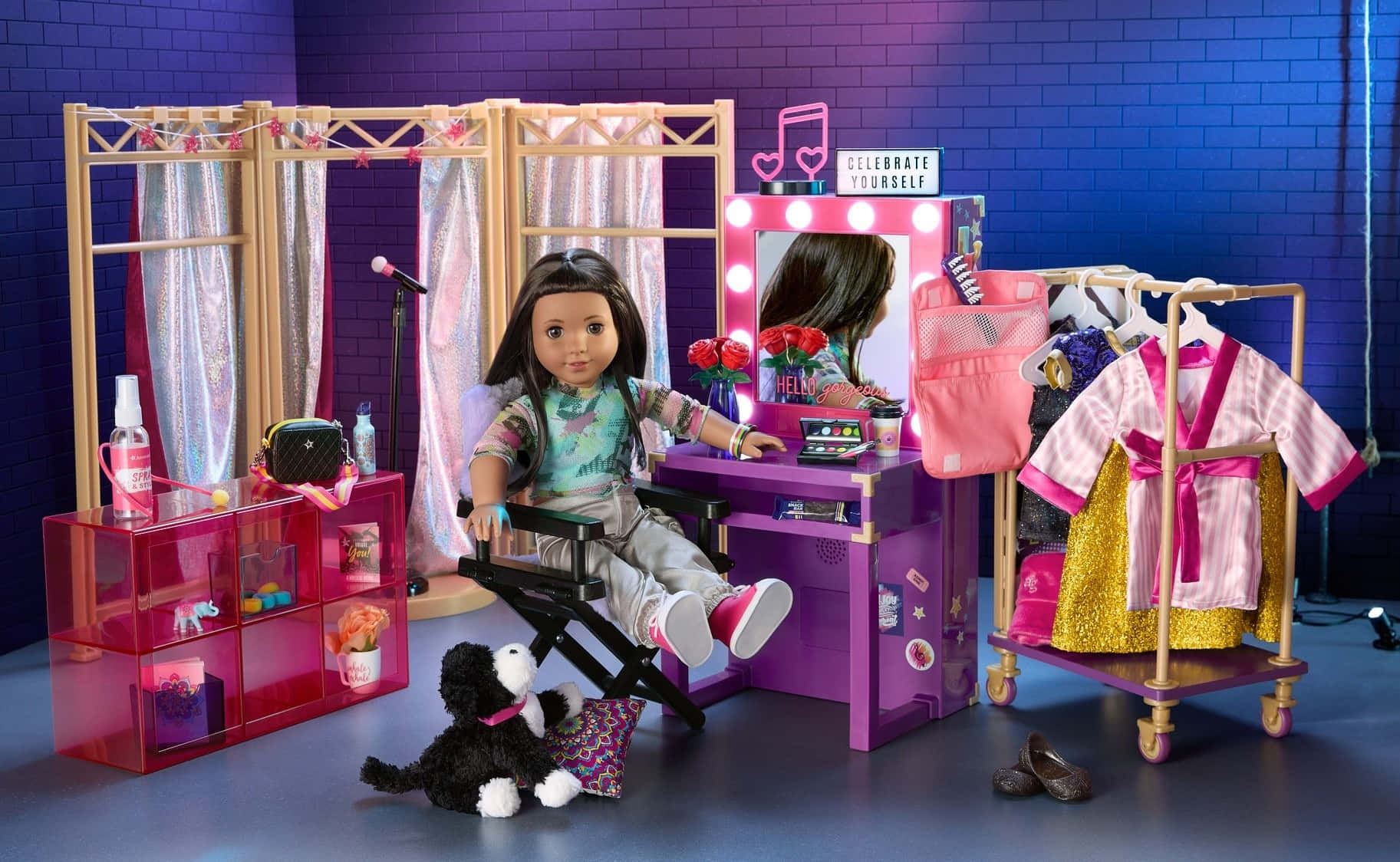 american girl 桌布 壁紙 — 一個玩偶坐在導演椅上，身處一個充滿活力的紫色化妝間，有閃閃發光的窗簾和一個衣架。
