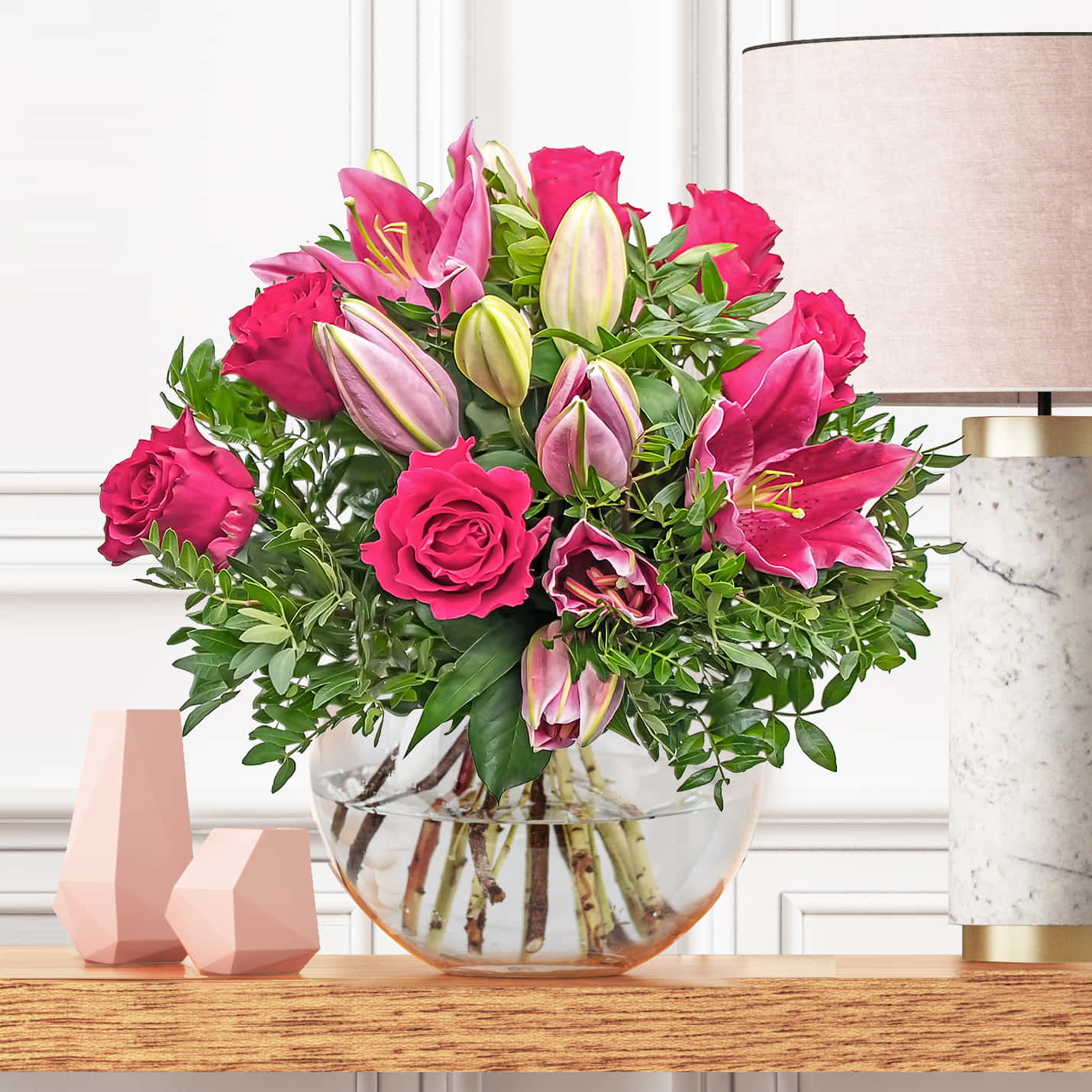 Beautiful Flower 桌布 壁紙 — 一個玻璃碗中盛放著充滿活力的粉紅玫瑰和百合花束，放在木桌上，旁邊是大理石燈和幾何裝飾。