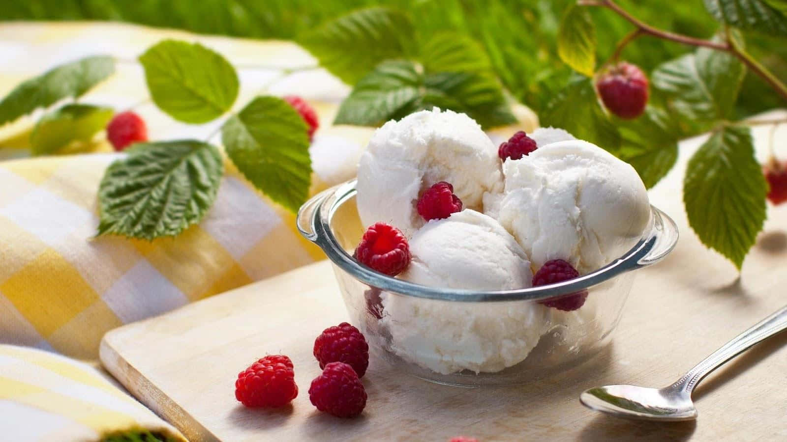 Ice Cream 桌布 壁紙 — 一個玻璃碗盛裝著奶油香草冰淇淋，上面放上新鮮紅覆盆子和綠葉，置於木板上。