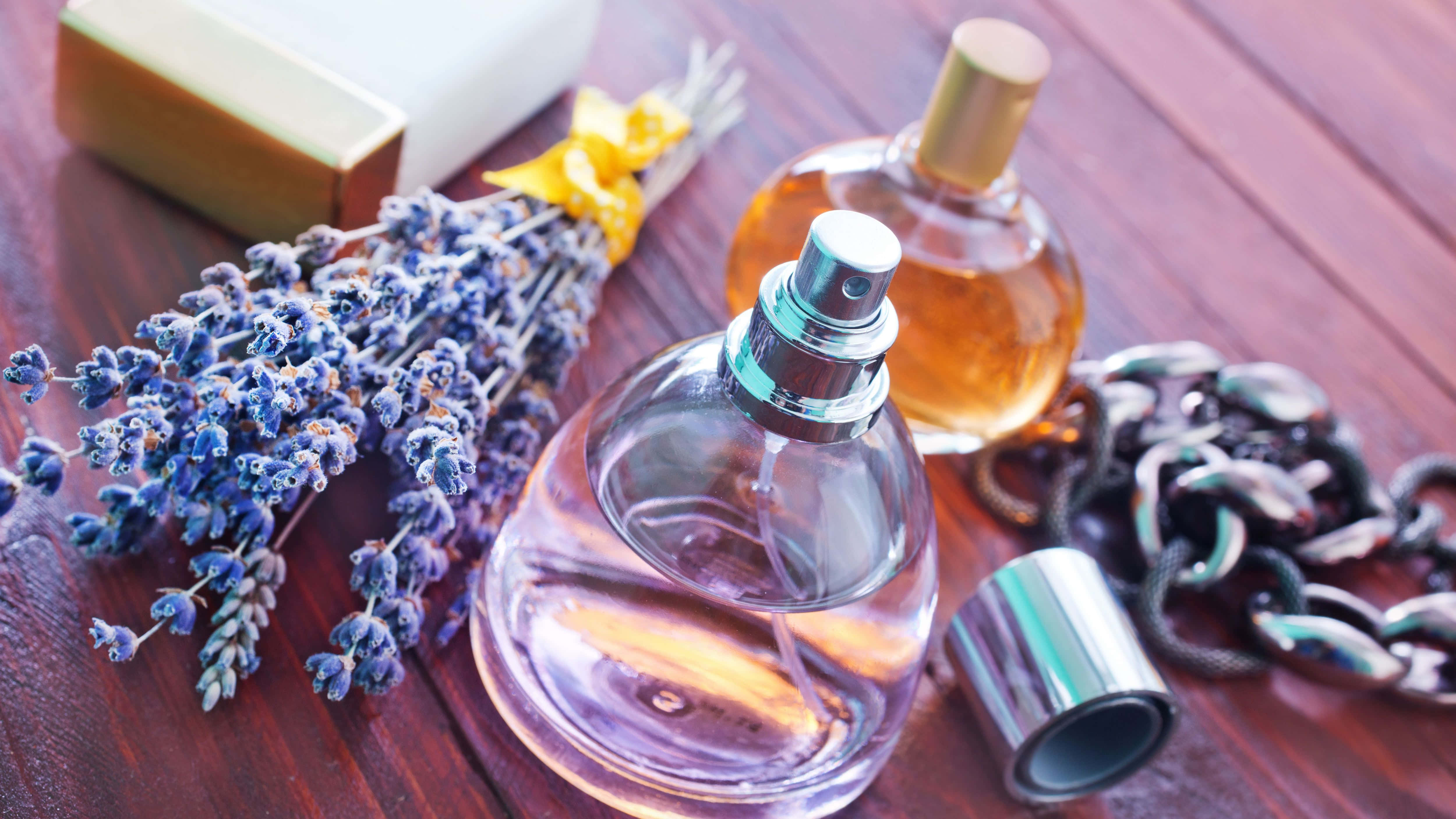 Fragrance 桌布 壁紙 — 一個玻璃香水瓶，帶有薰衣草枝條和一條鏈條，放置在一個豐富的木質表面上，旁邊有一塊肥皂。