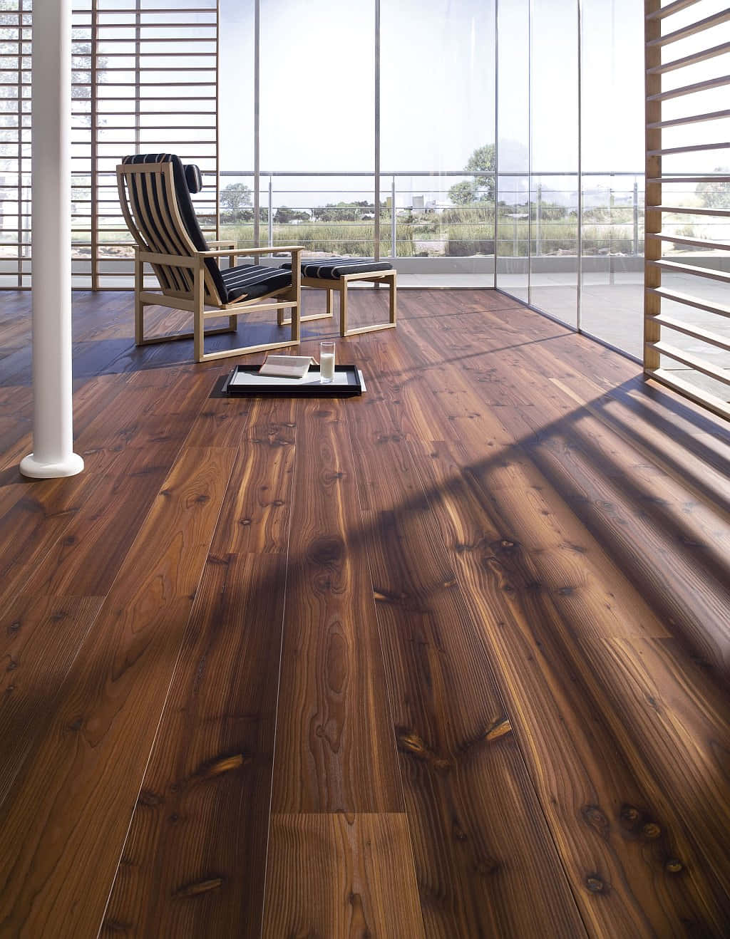 Wooden Floor 桌布 壁紙 — 一個現代化的休息室，擁有豐富的木地板和黑色條紋椅子，沐浴在大玻璃窗的自然光中。