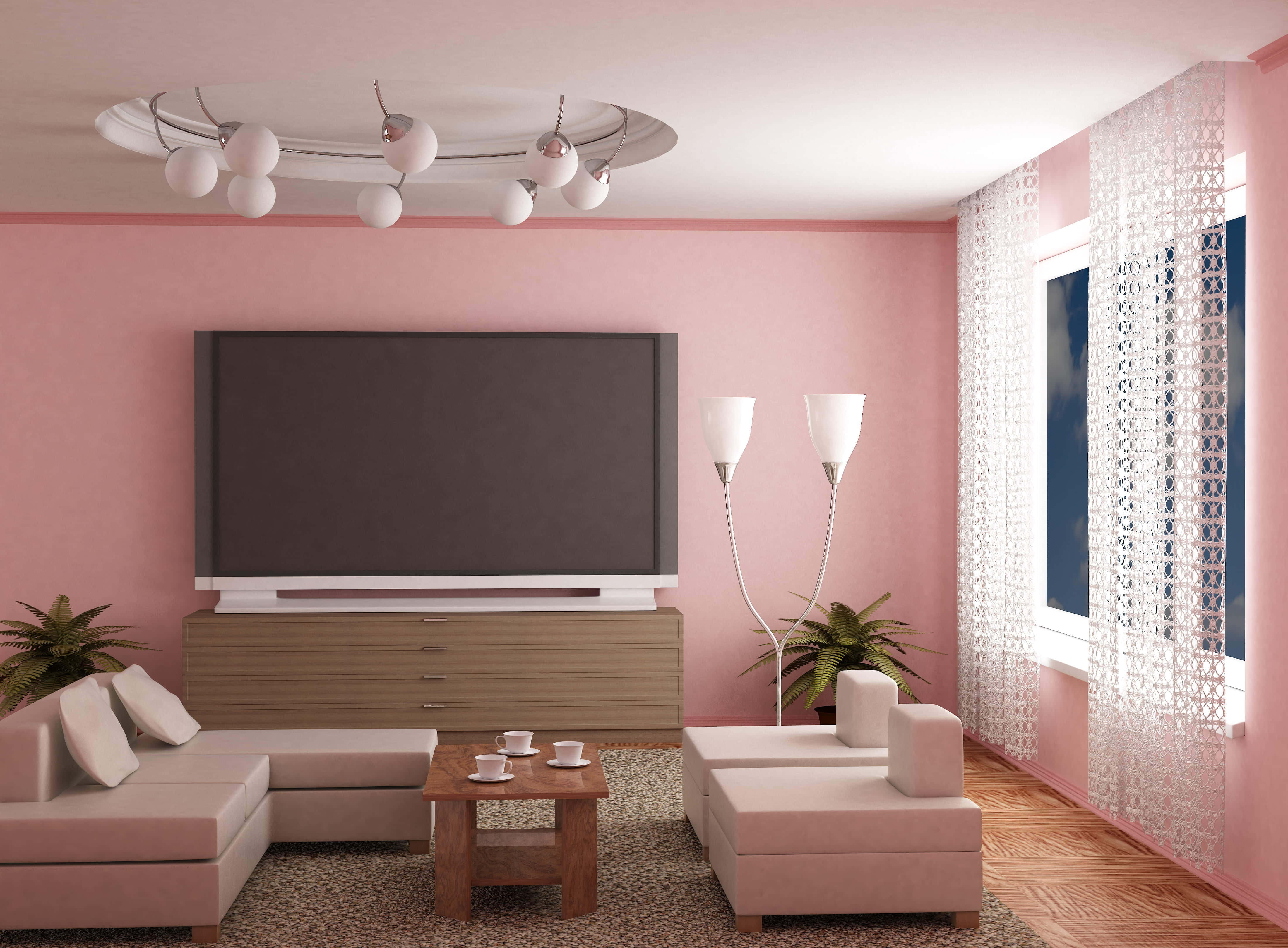 Home Cinema 桌布 壁紙 — 一個現代化的客廳，粉紅色牆壁，木櫃上方有一台大電視，淺色沙發圍繞著木茶几擺放。