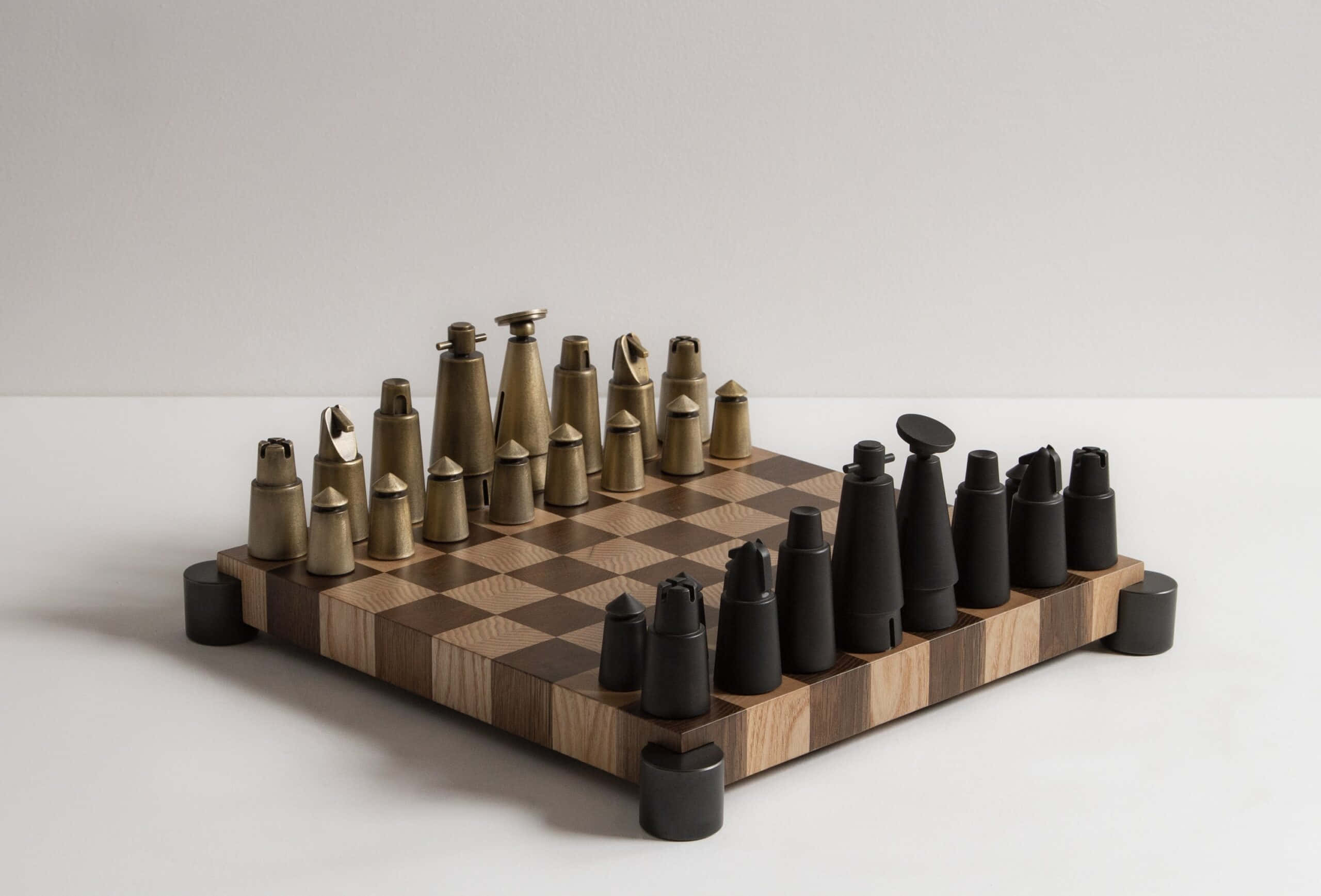 Chessboard 桌布 壁紙 — 一個現代國際象棋套裝，帶有金屬和霧面黑色棋子，放在木製棋盤上，背景為簡約白色。