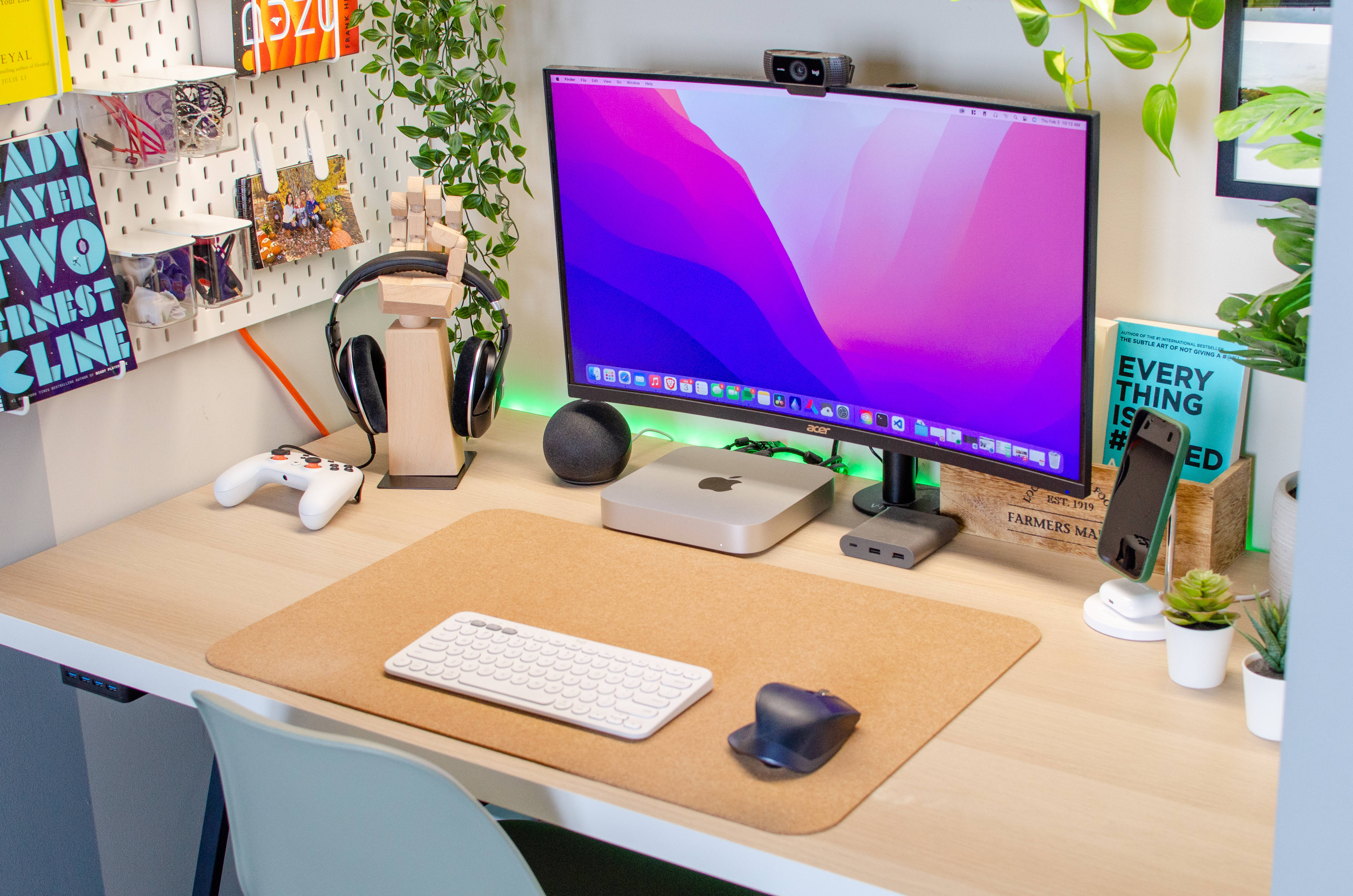 Webcam 桌布 壁紙 — 一個現代家居辦公桌，配有彩色顯示器、遊戲耳機和植物，在明亮的日光下。