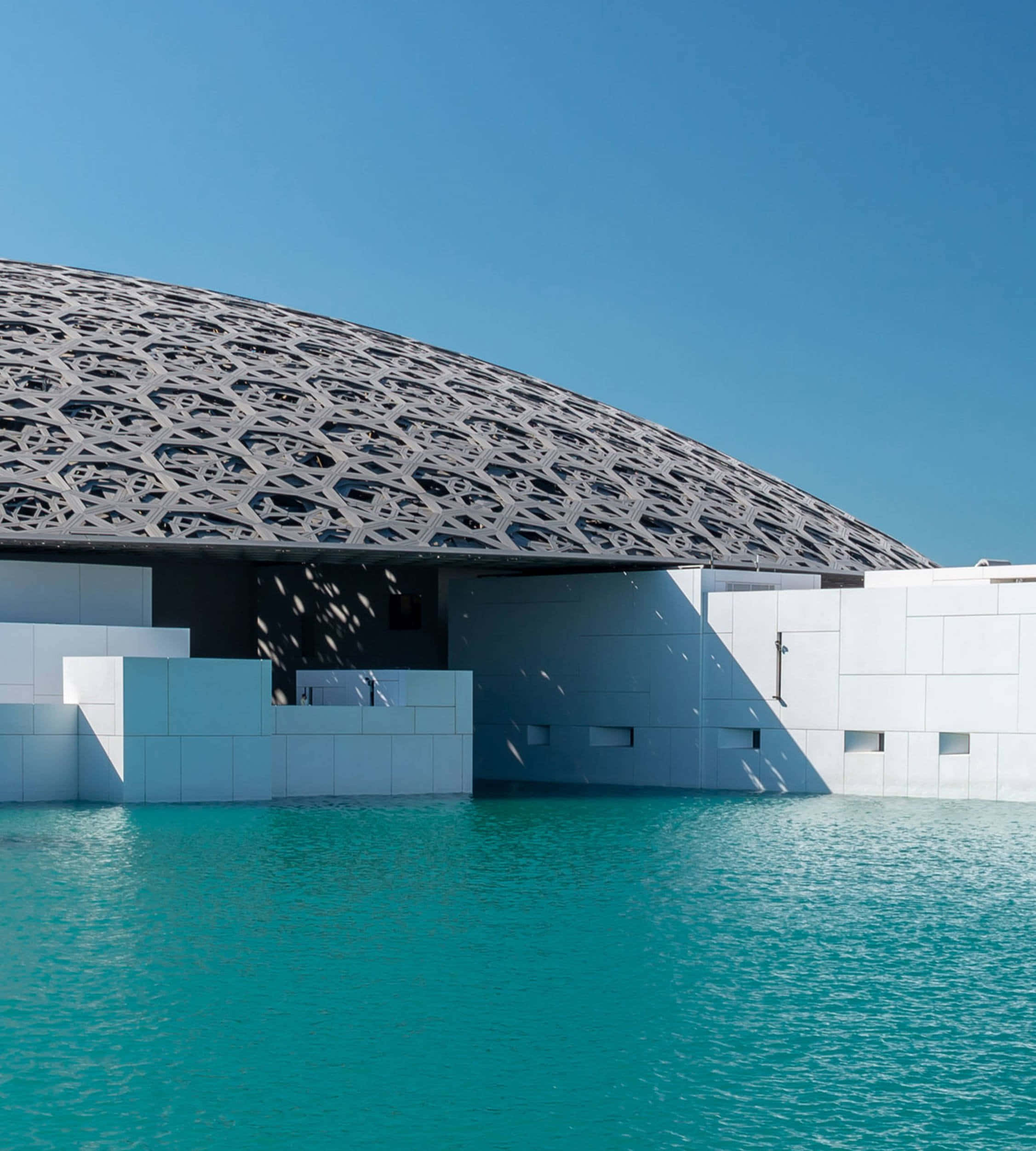 Beautiful Architecture 桌布 壁紙 — 一個現代建築奇蹟，擁有幾何圓頂和白色牆壁，被碧綠色的海水環繞，在清澈的藍天下。