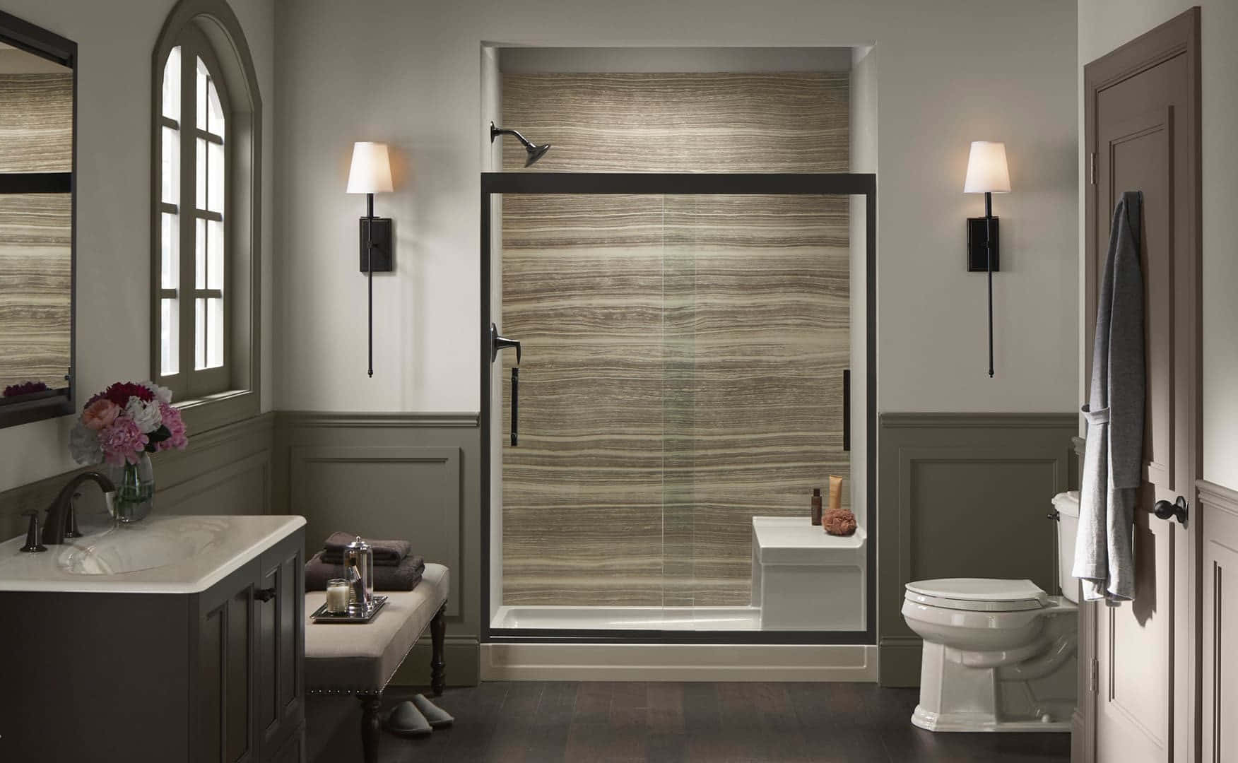 Bathroom Decor 桌布 壁紙 — 一個現代浴室，配有灰色護牆板、玻璃淋浴間（帶木紋磚）和溫暖的壁燈照明。